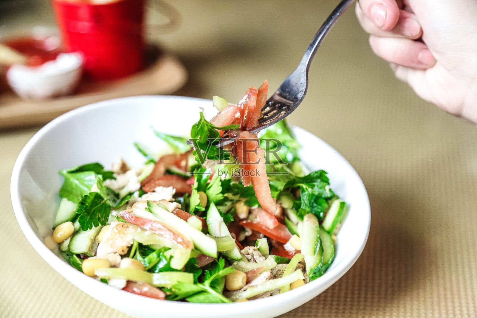 在盛食物的碗里拿着叉子的人照片摄影图片