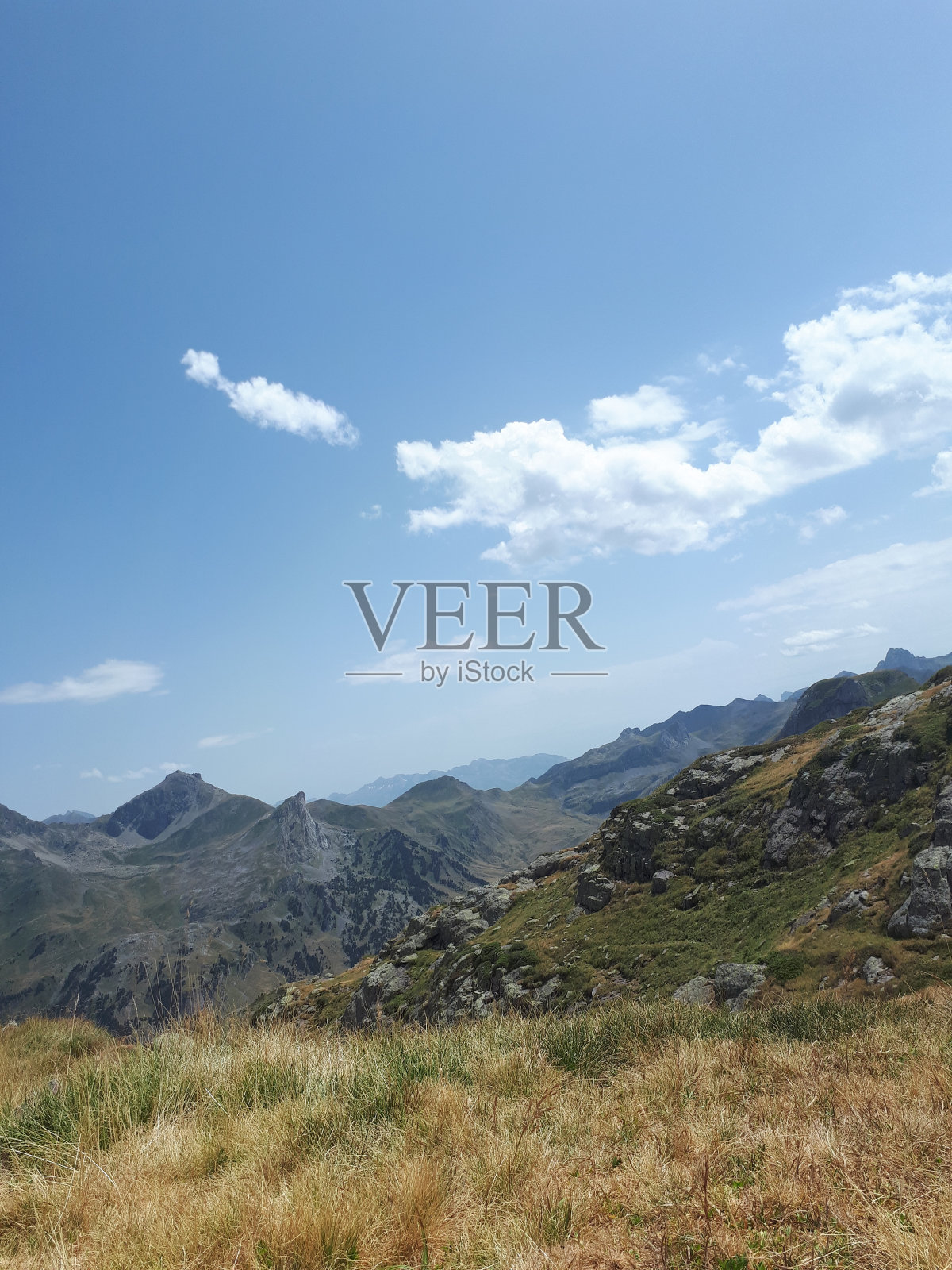 从一片泛黄的草地上俯瞰群山照片摄影图片