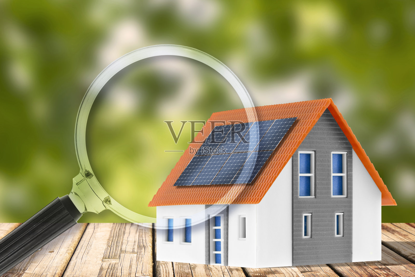 住宅建筑上的光伏系统安装-概念与家用模型和放大镜照片摄影图片