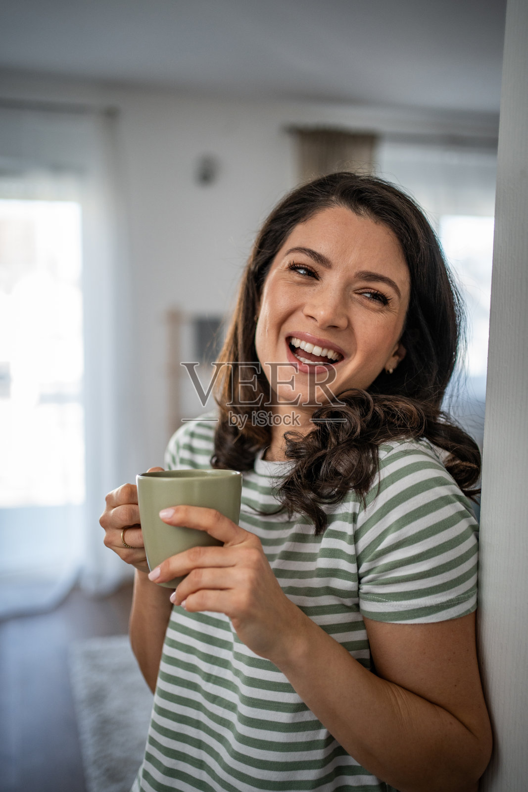 平静的春天早晨——一位年轻女子在她的公寓里享受着早晨的咖啡照片摄影图片