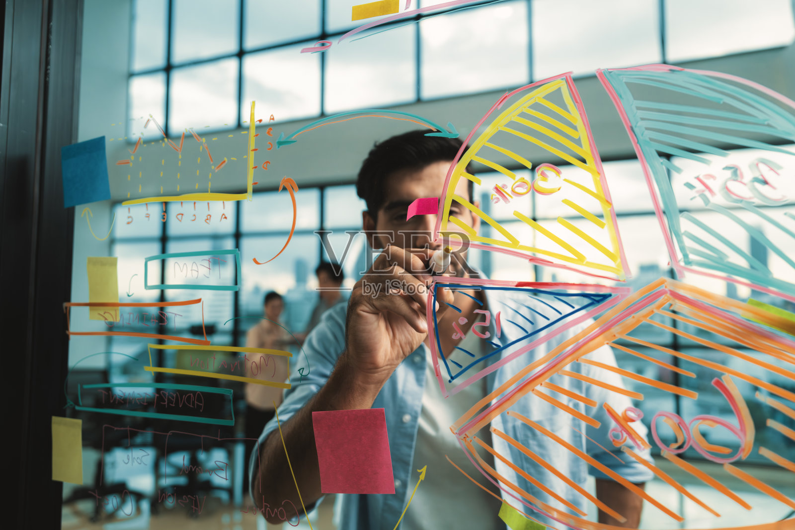 英俊商人的肖像在玻璃墙上写着营销理念。窗饰。照片摄影图片