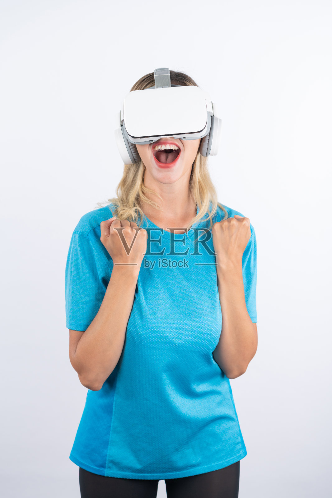 高加索快乐女孩戴着虚拟现实眼镜做赢家手势。精巧的设计。照片摄影图片