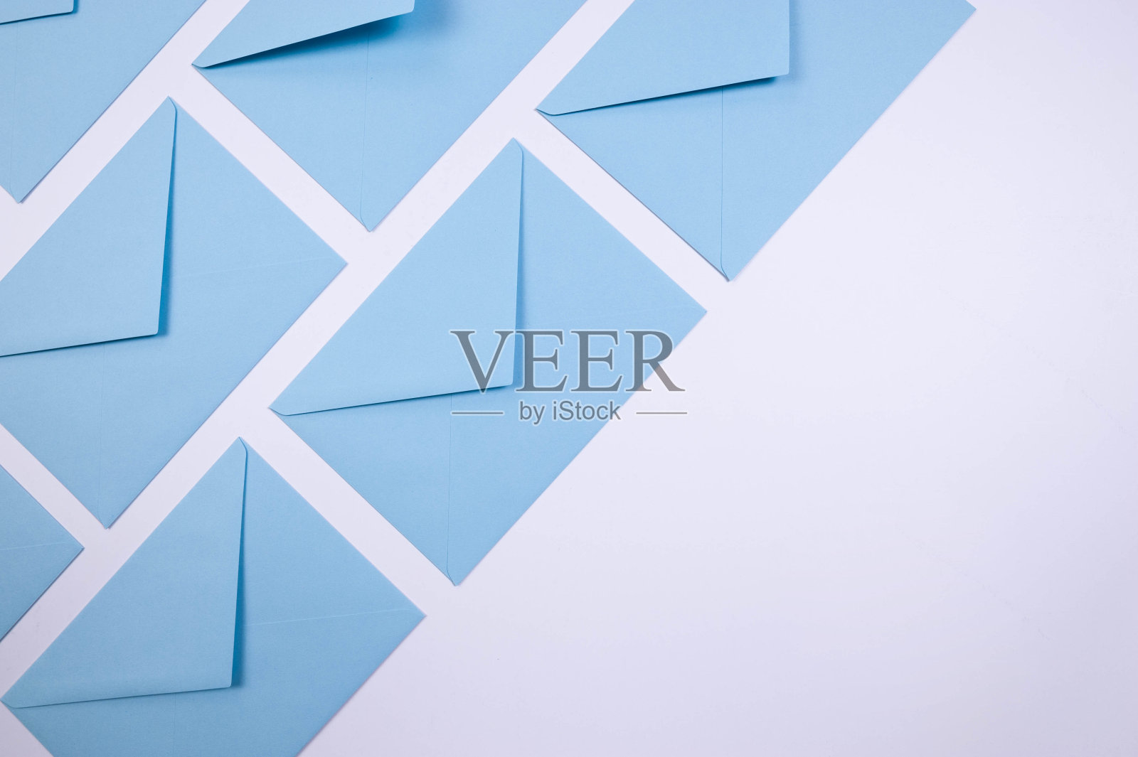 白色背景上浅蓝色信封的俯视图。后平铺。照片摄影图片