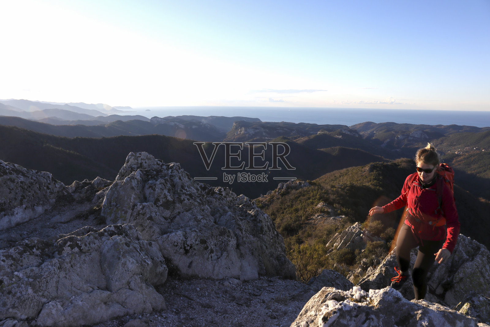 年轻女子爬上山顶照片摄影图片