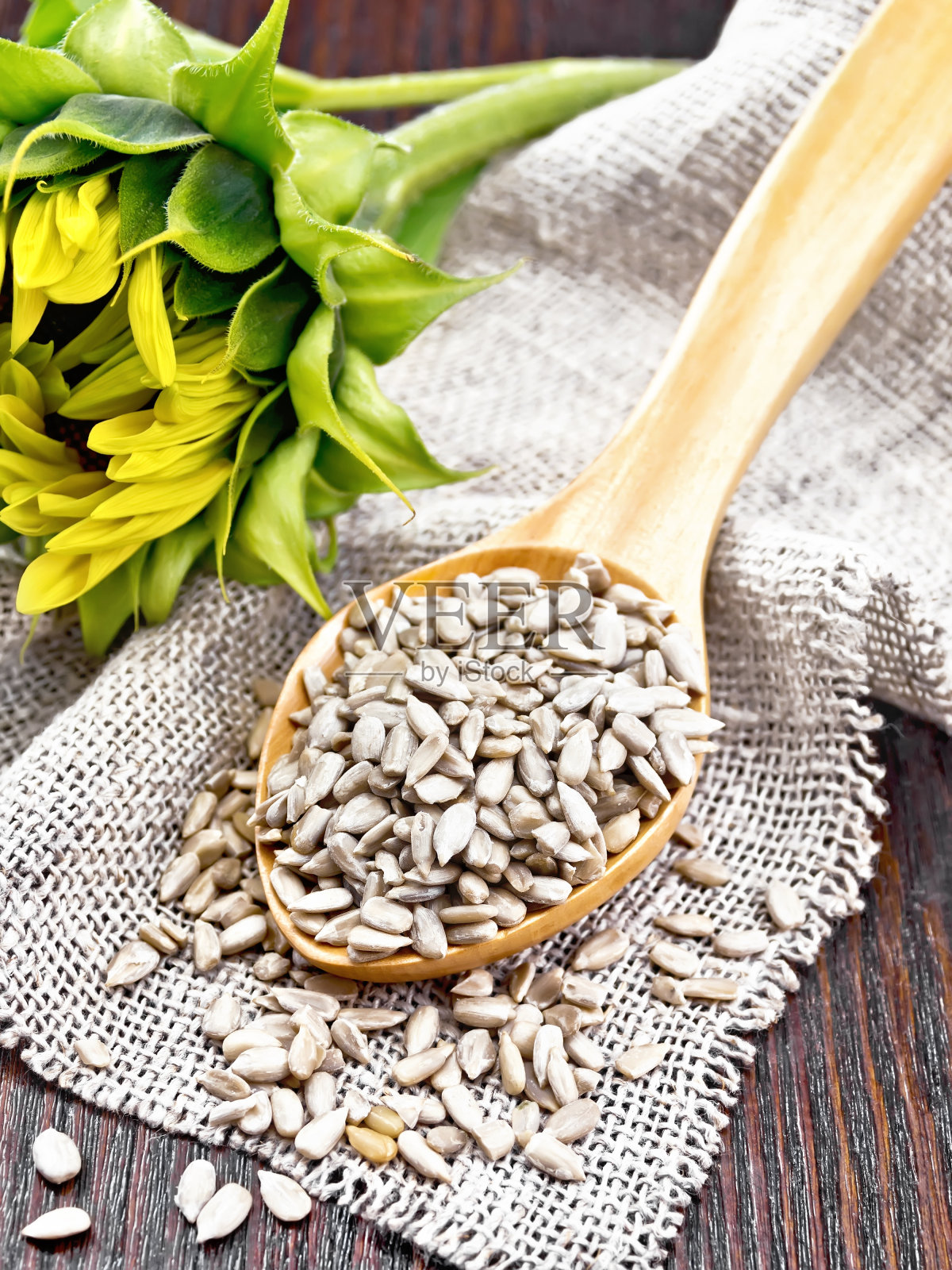 葵花籽去皮,用勺子放在暗板上照片摄影图片