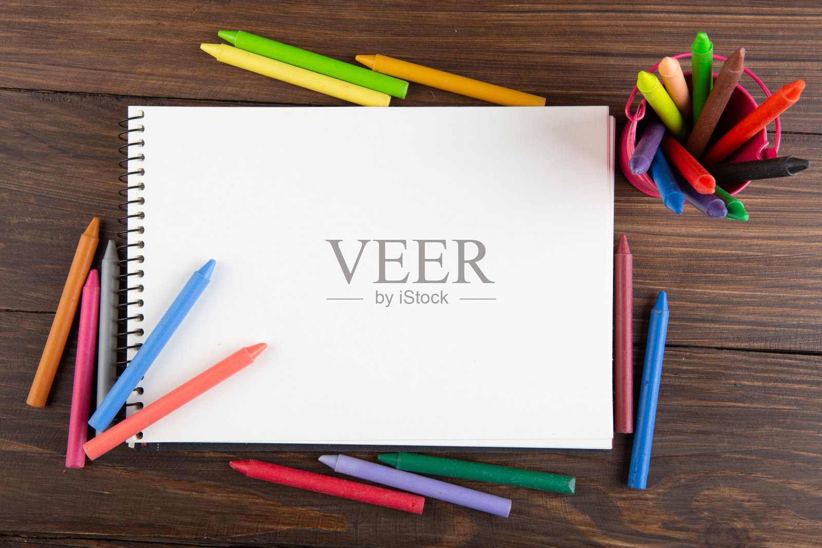 木桌上的彩色蜡笔和白纸照片摄影图片