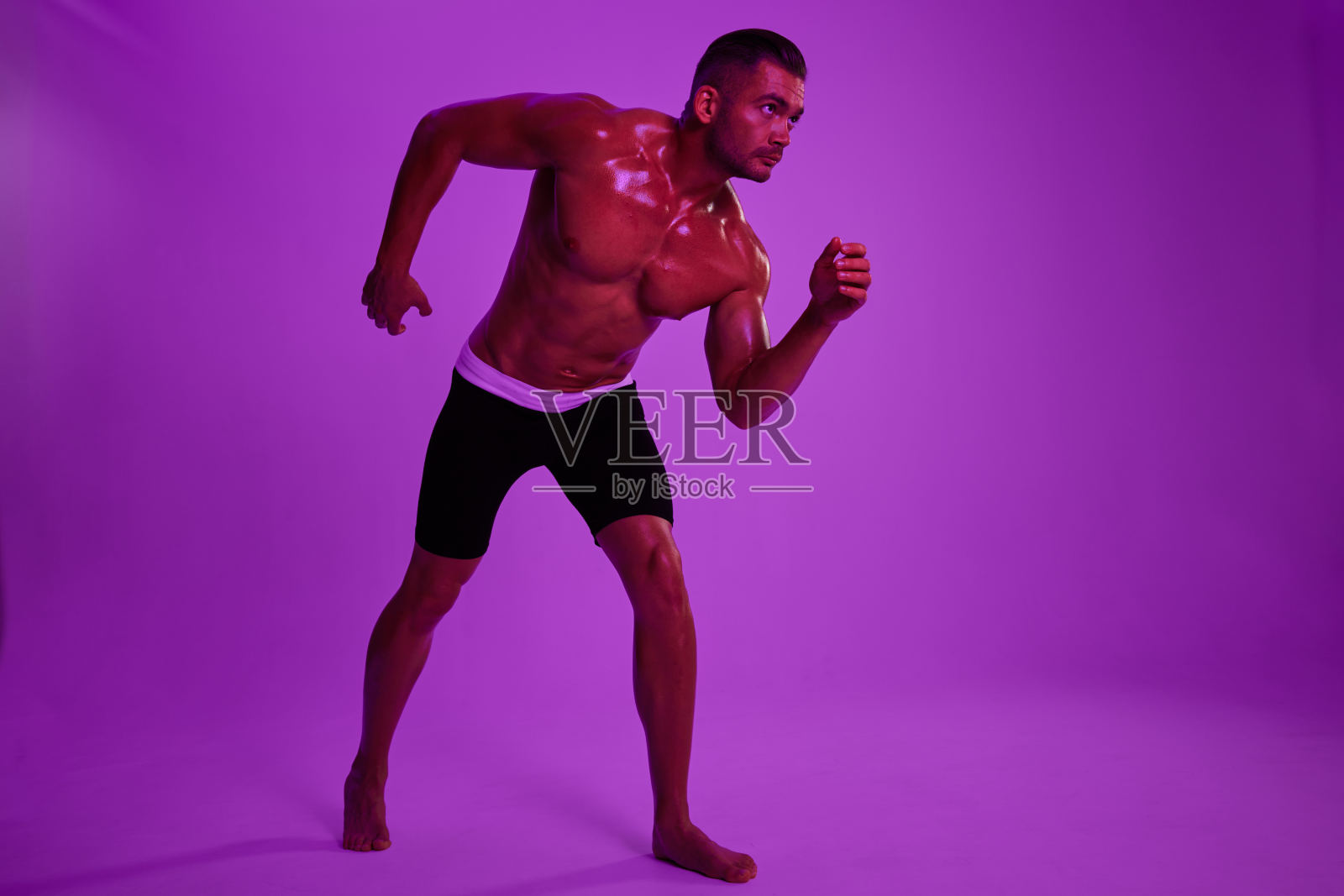 男子健美运动员摆出躯干腹肌的全身背景,拳击和武术。广告、运动、活跃的生活方式、彩光、竞争、挑战的理念。照片摄影图片