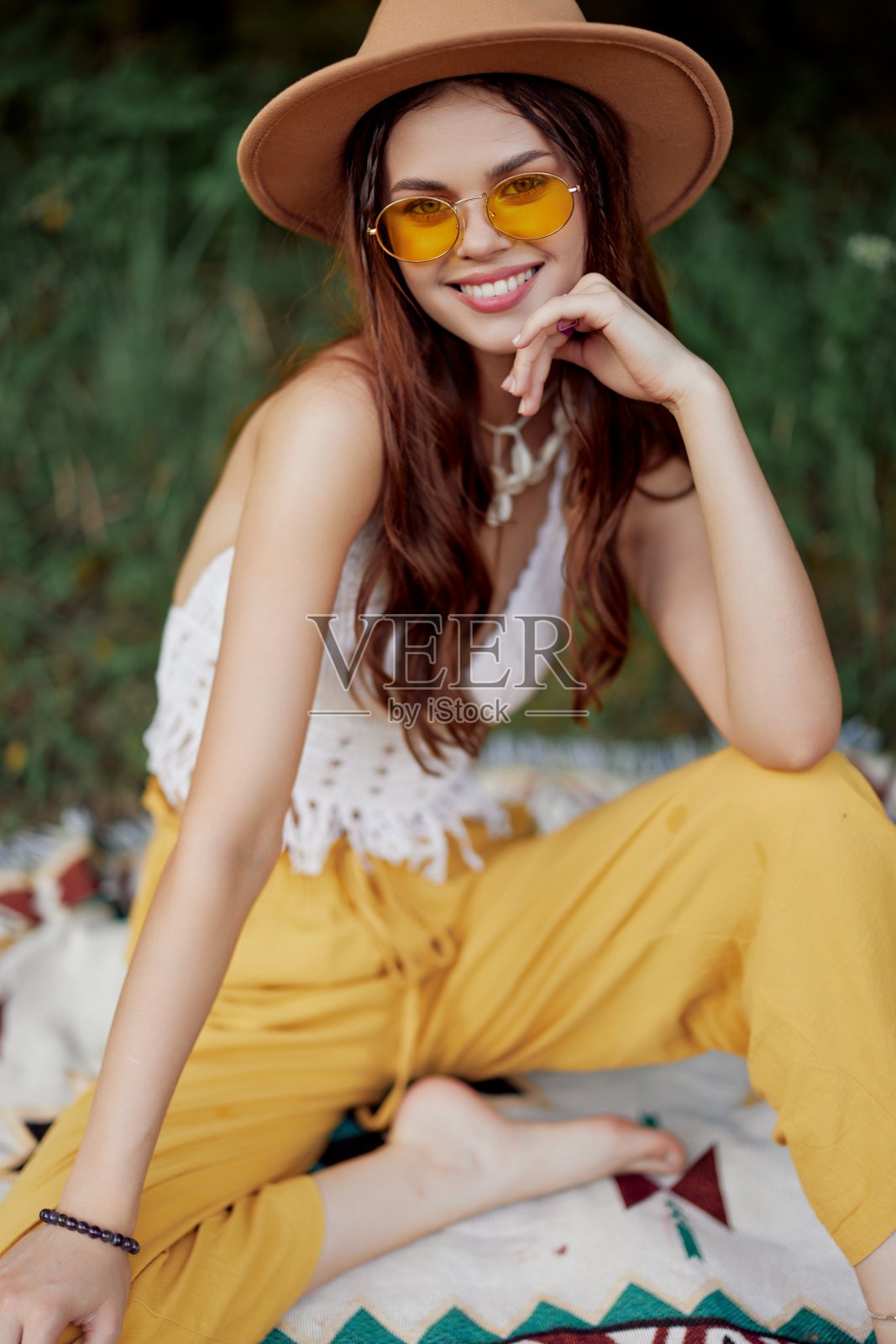 美丽的年轻女孩特写镜头,戴着帽子,戴着生态嬉皮户外,美丽的微笑与牙齿在夕阳下照片摄影图片