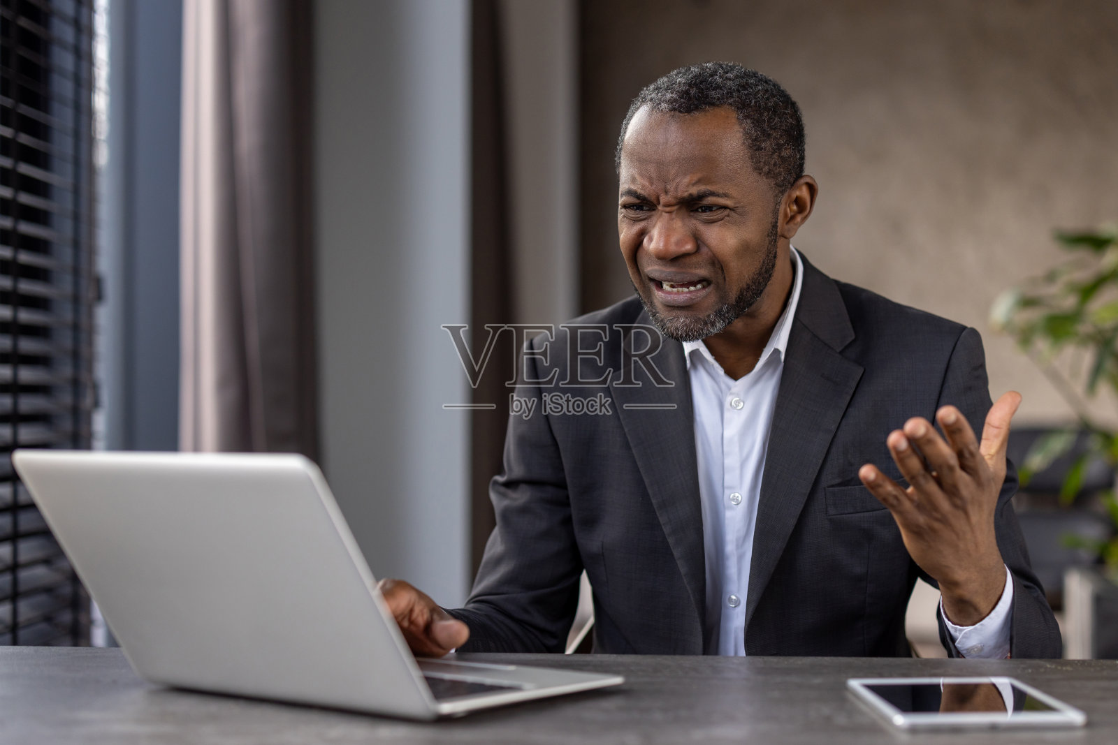 在家办公,对笔记本电脑屏幕感到困惑的黑人男性照片摄影图片