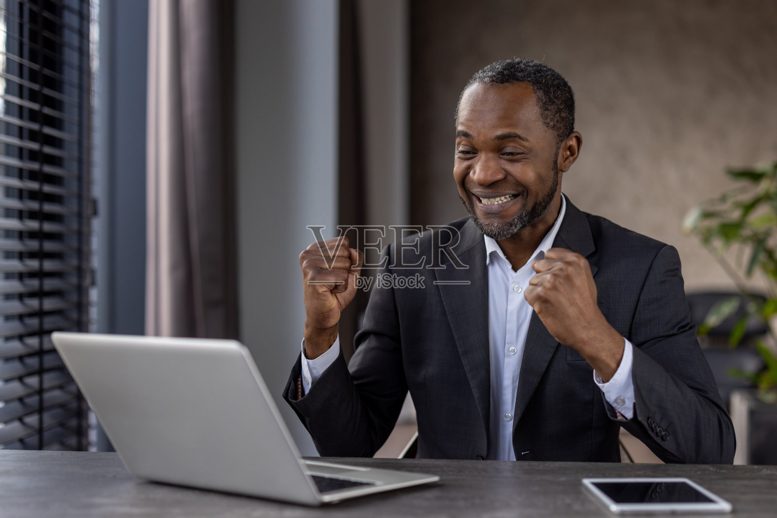 快乐的非裔美国商人在办公室庆祝成功照片摄影图片