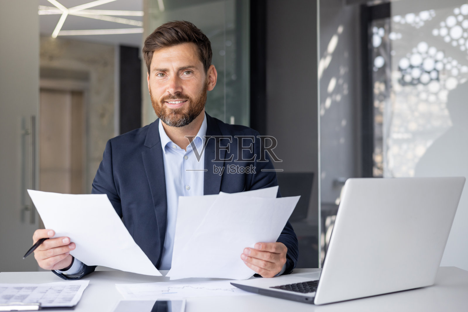 在现代化的办公室里,微笑着处理文书工作的会计照片摄影图片