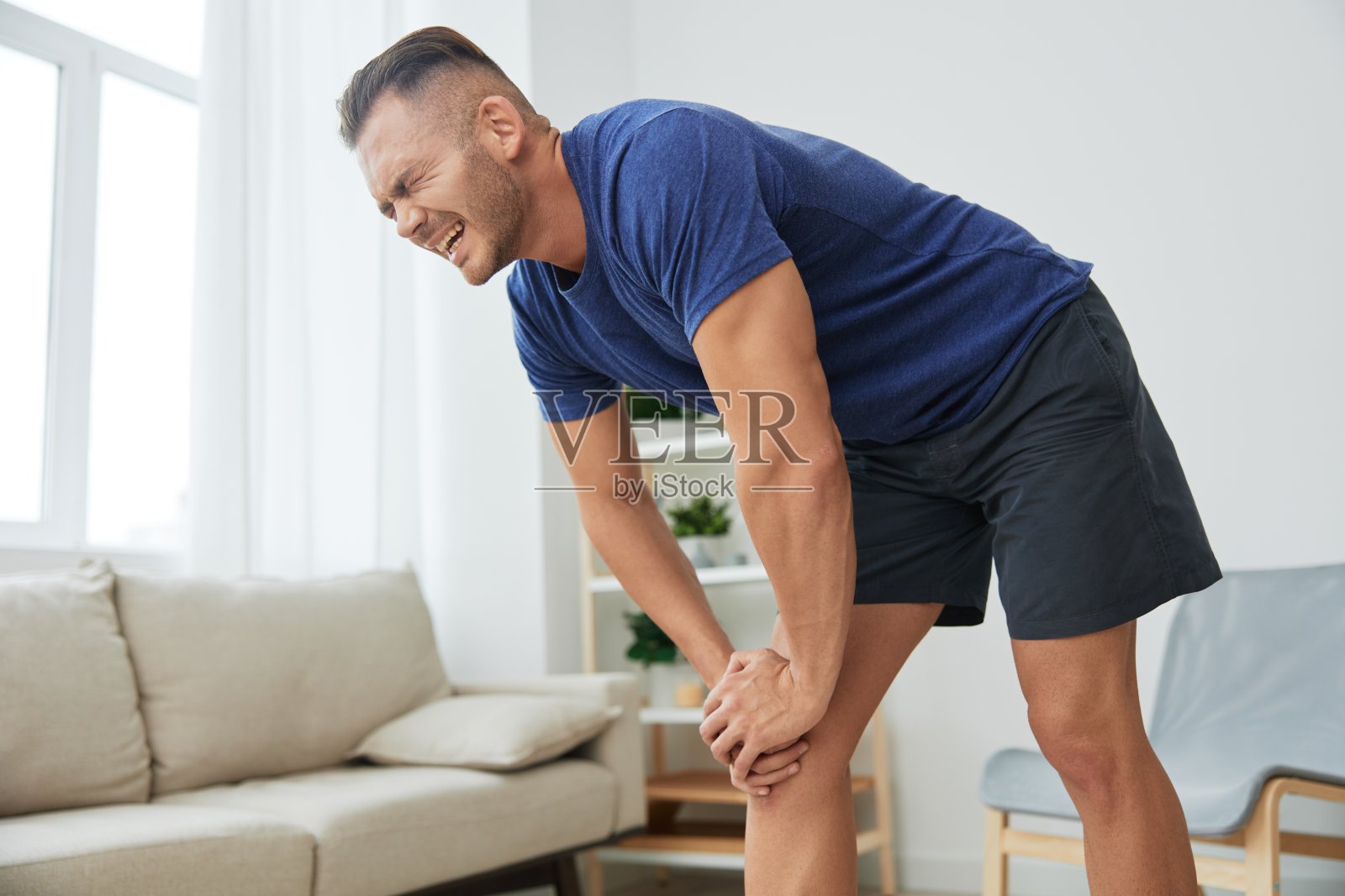 男性腿部疼痛源于在家锻炼,锻炼损伤,肌肉和韧带扭伤,瘀伤照片摄影图片