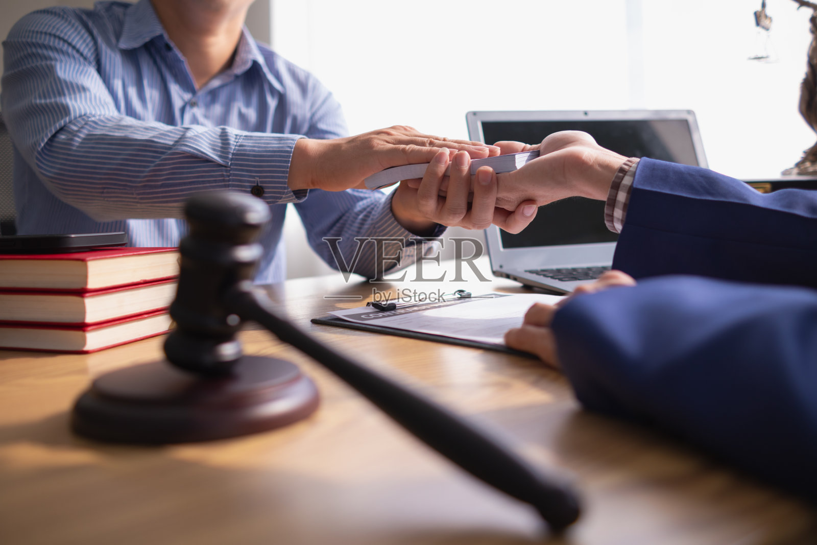 在严重案件中,被告贿赂参与法院判决的官员,以改变案件进程的概念,通过贿赂来促进律师团队和检察官。贿赂的概念照片摄影图片