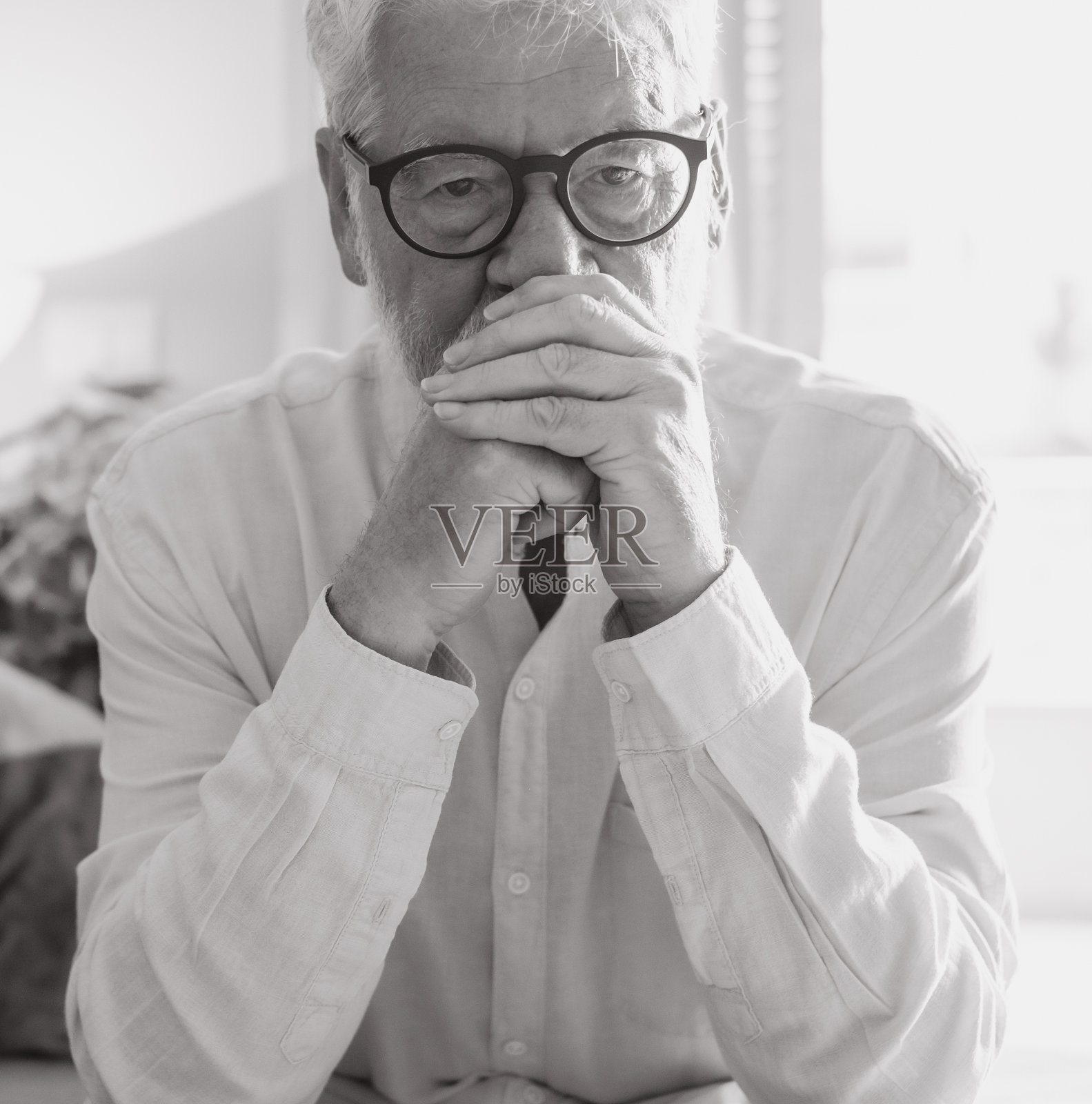 坐在家里的沙发上的不快乐的白发老人的黑白肖像照片摄影图片