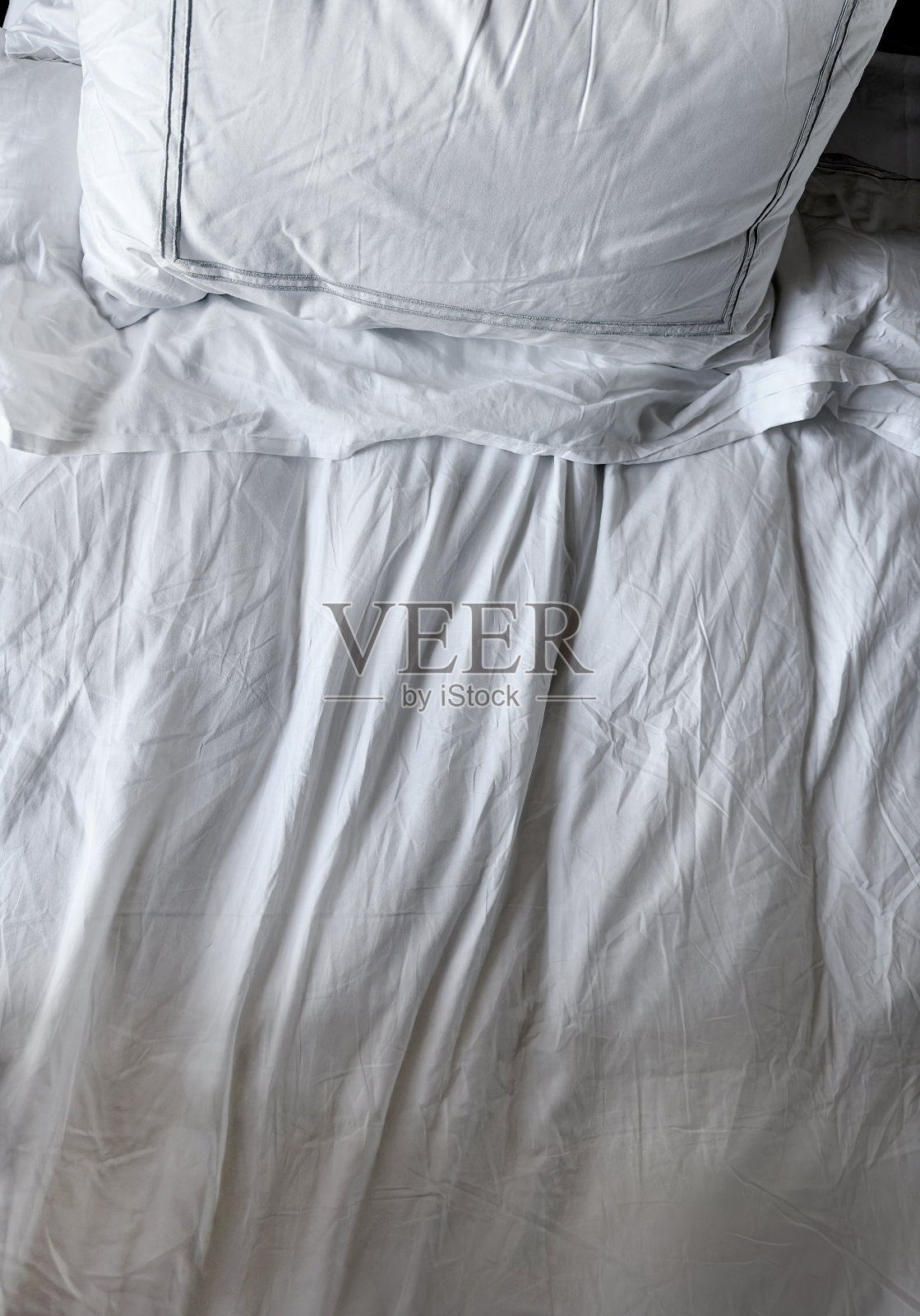 靠近白色床单和枕头的床面照片摄影图片