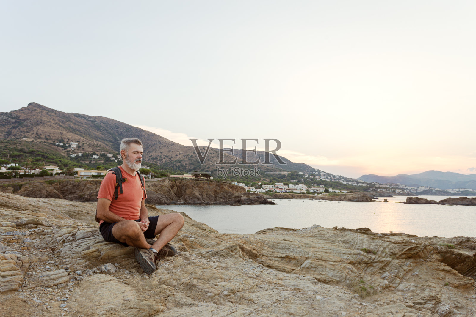 一个人坐在地板上冥想。照片摄影图片