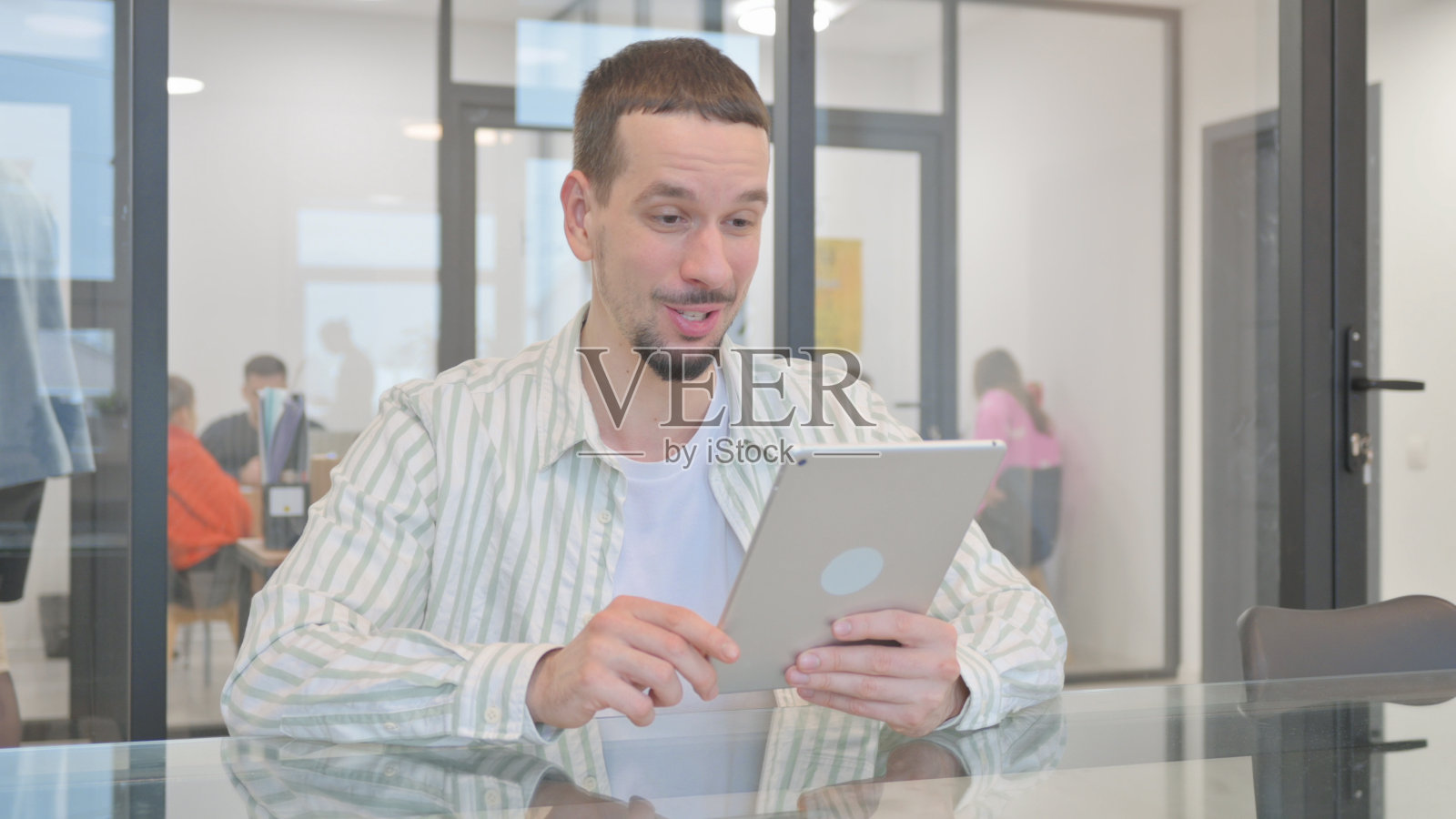 创意青年在办公室用平板电脑视频聊天照片摄影图片