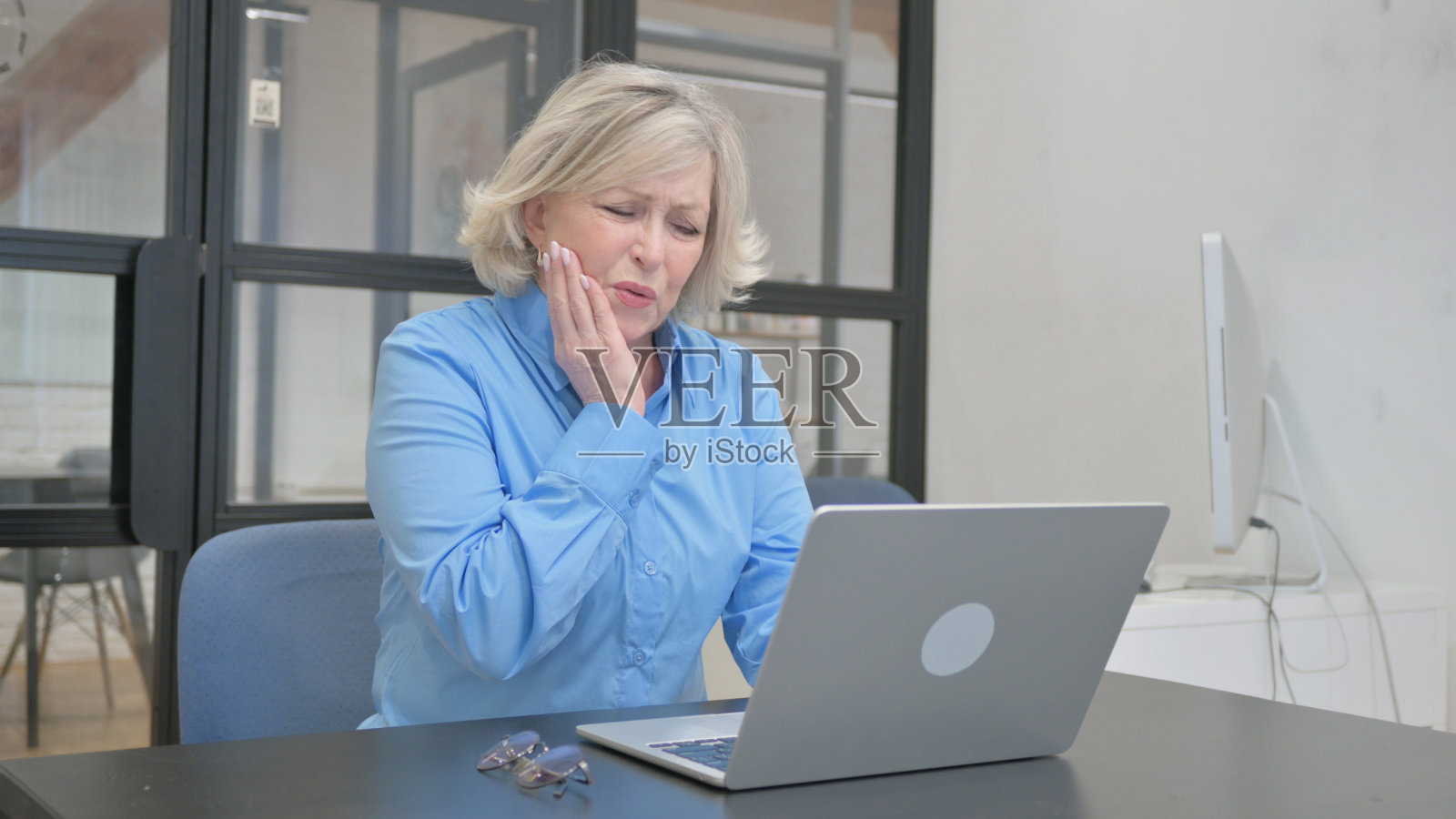 办公室里牙痛的老女人照片摄影图片