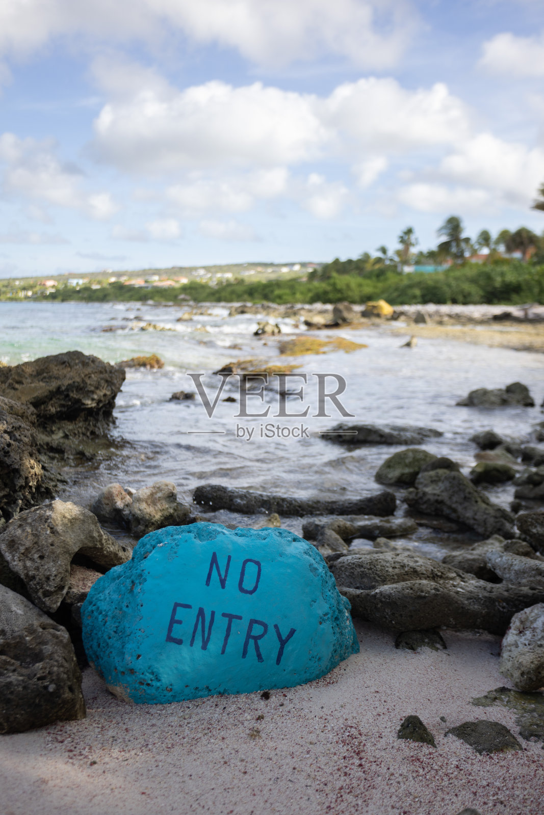 在通往入海口的岩石海滩上有警告标志。不准入海。照片摄影图片