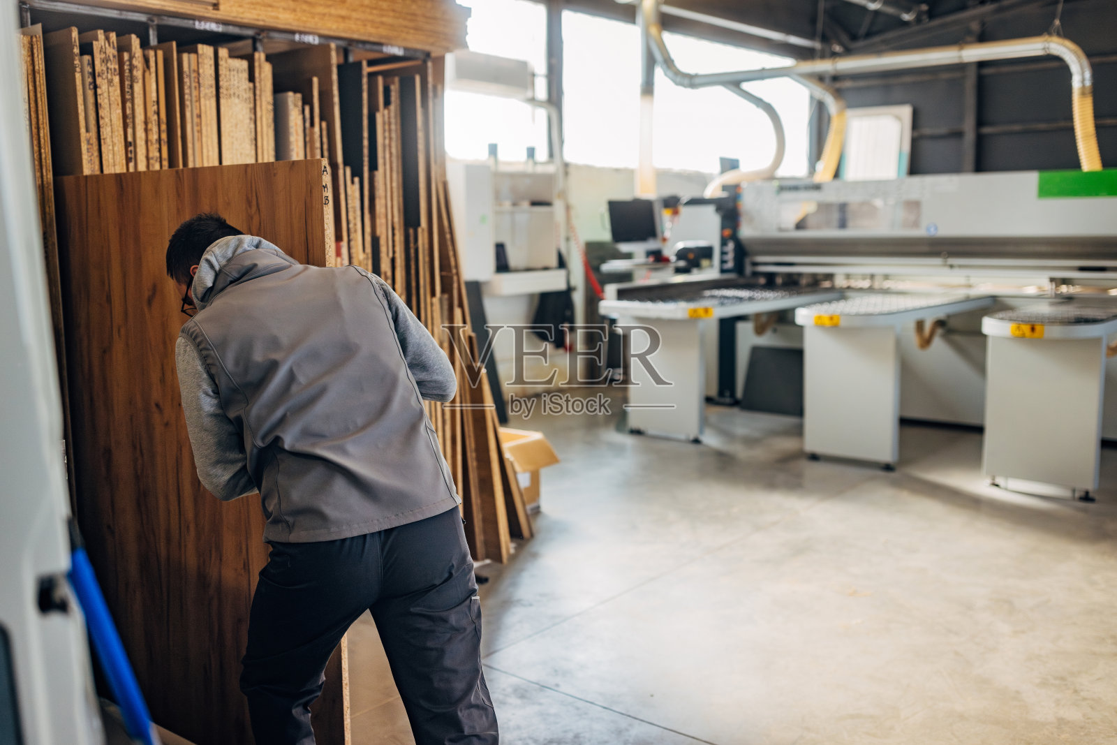 家具车间的工人正在挑选刨花板进行加工照片摄影图片