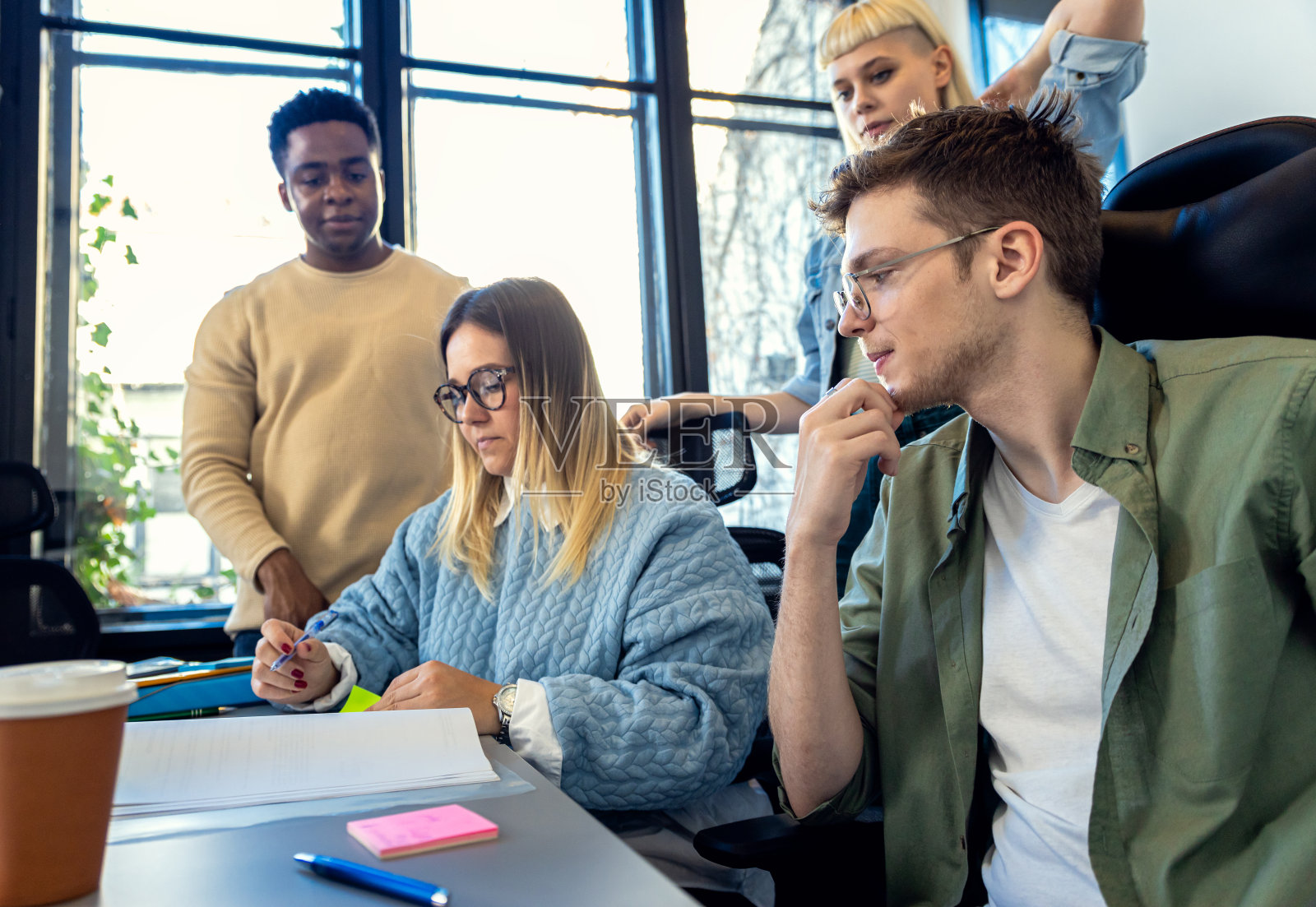 一群不同的年轻商人在办公室里一起做新项目。照片摄影图片