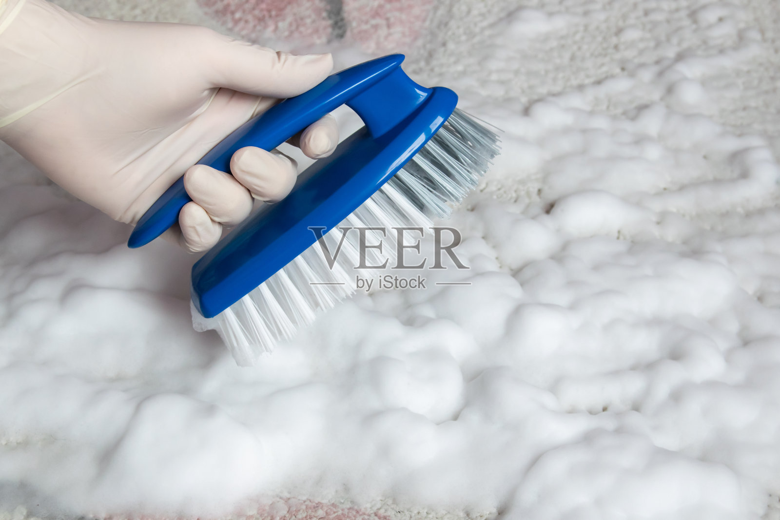蓝色的刷子放在地板上,手戴着橡胶手套。清洗。照片摄影图片