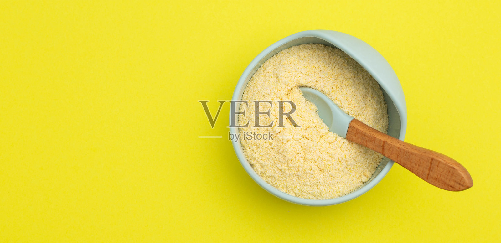 黄色背景的盘子里装着婴儿粥。适合宝宝生长发育的米粥。增强免疫力和健康。文本复制空间照片摄影图片