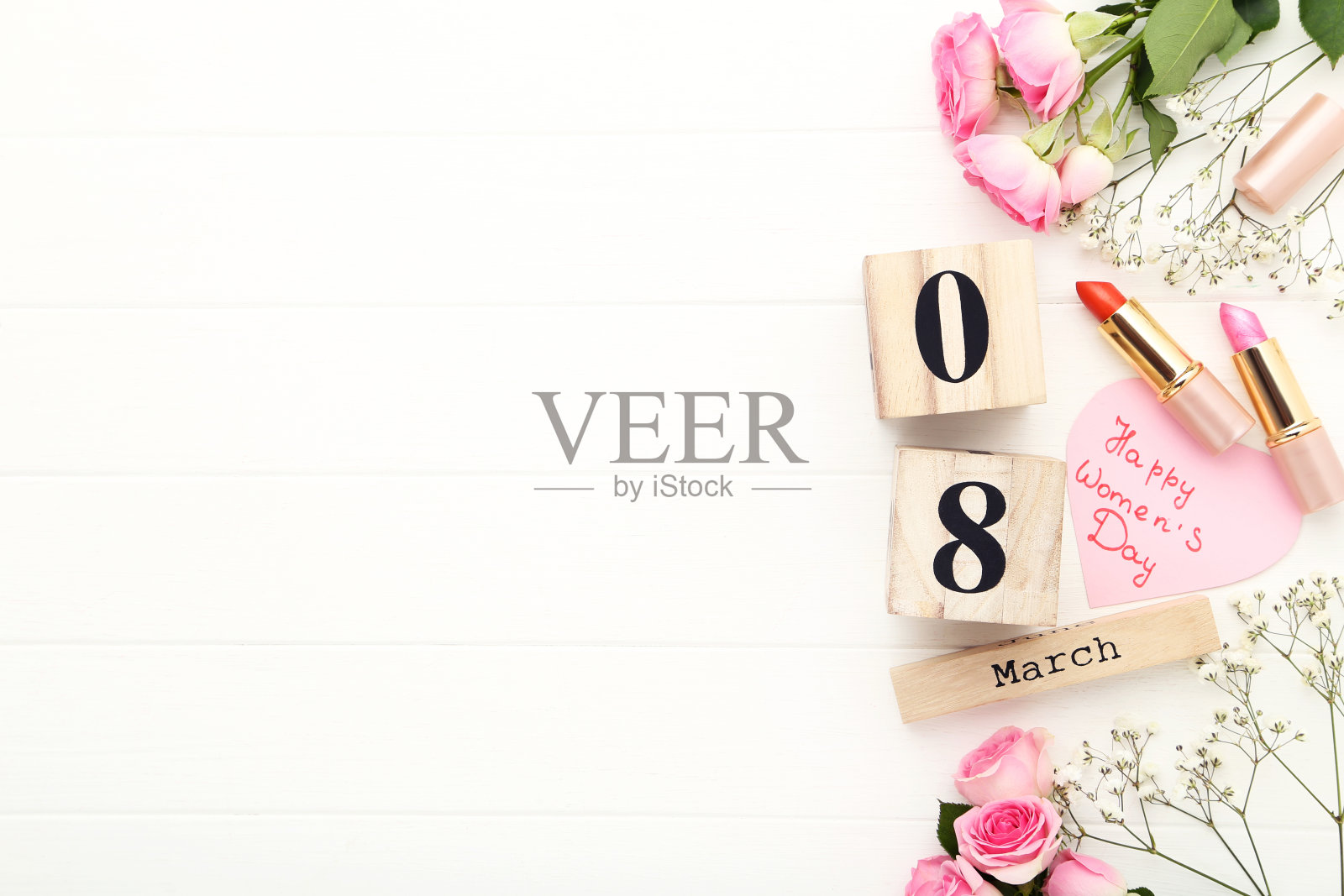 木制日历,文字妇女节快乐,白色背景上有鲜花和口红照片摄影图片