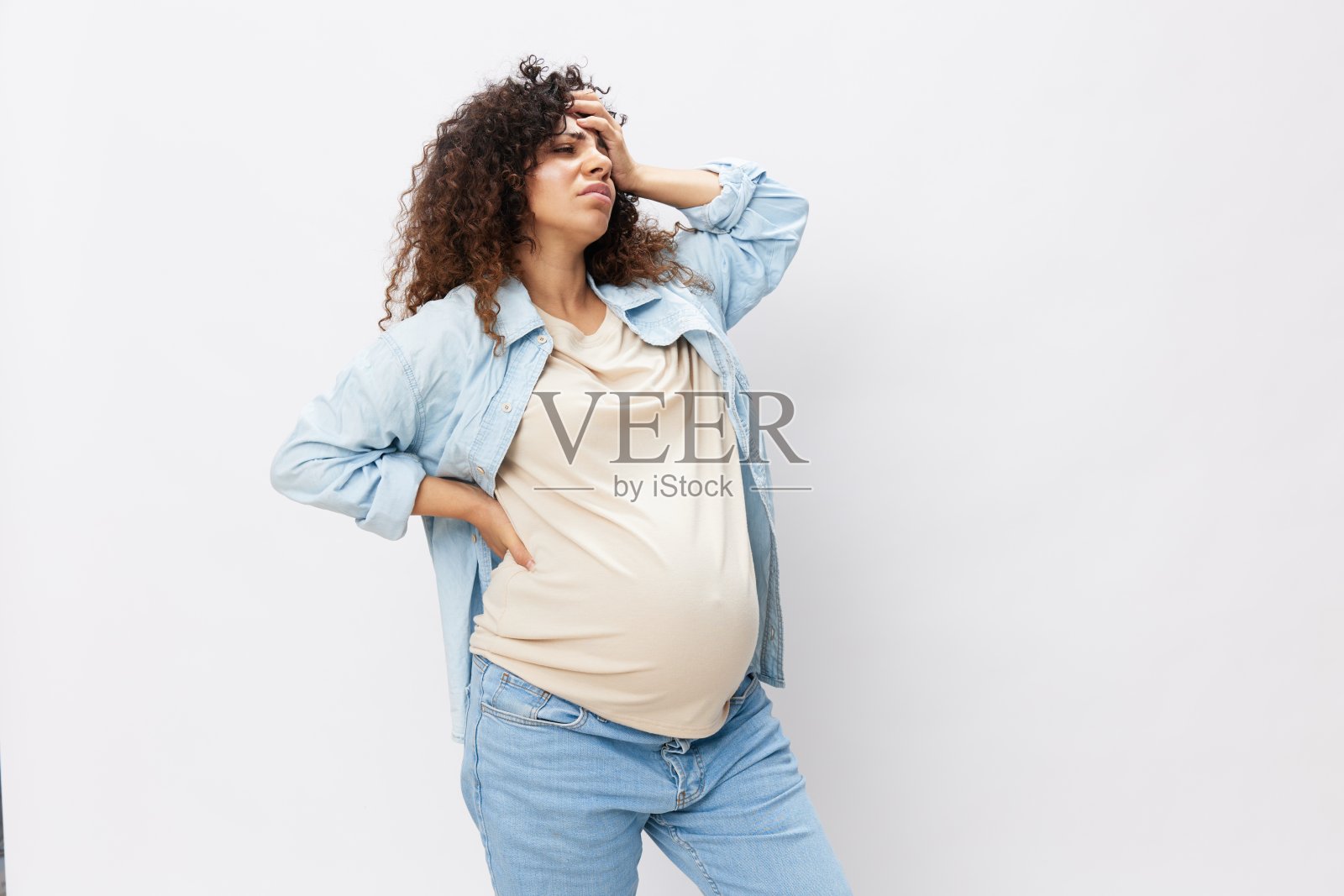 孕妇劳累,头痛腹痛,妊娠重,上月临产前身穿白色隔离背景的t恤配蓝色衬衫照片摄影图片