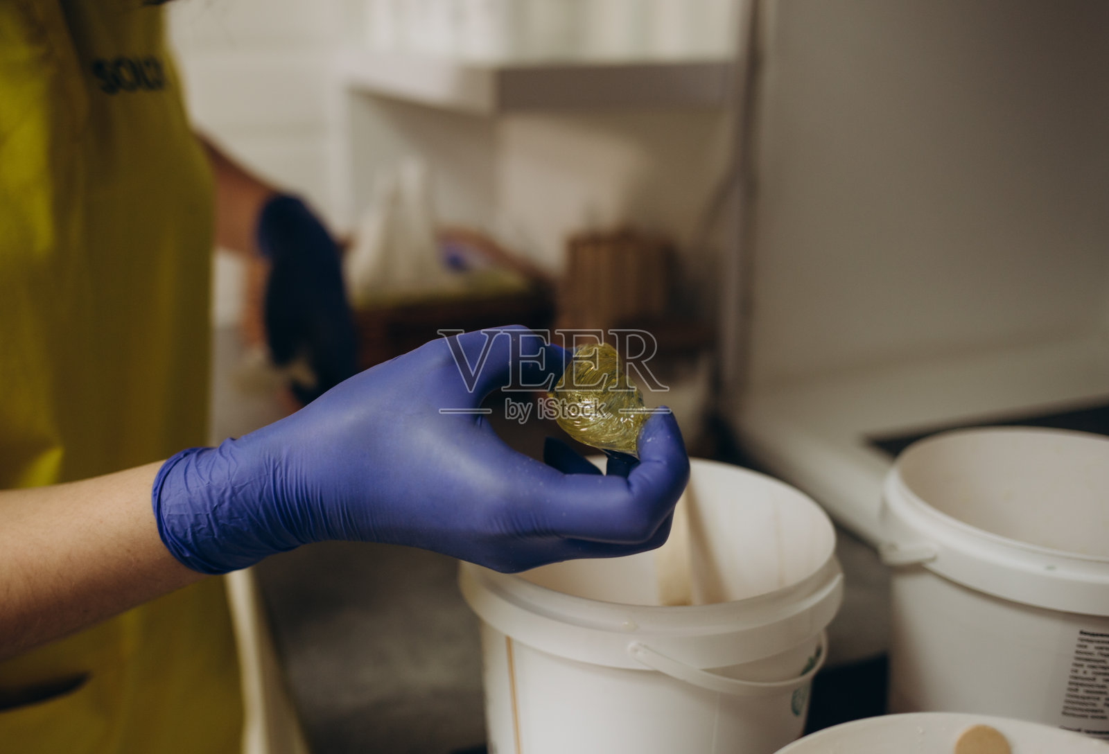 一名妇女在美甲沙龙接受美甲,她正在用石蜡或蜡沐浴她的手照片摄影图片