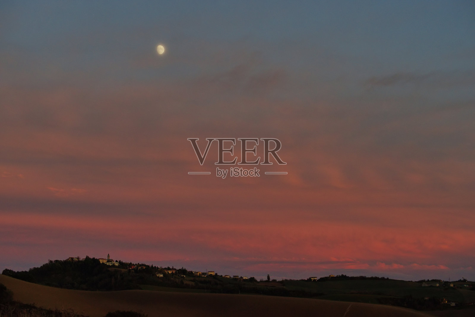 美丽的晚霞和白云映衬着小山的景色照片摄影图片