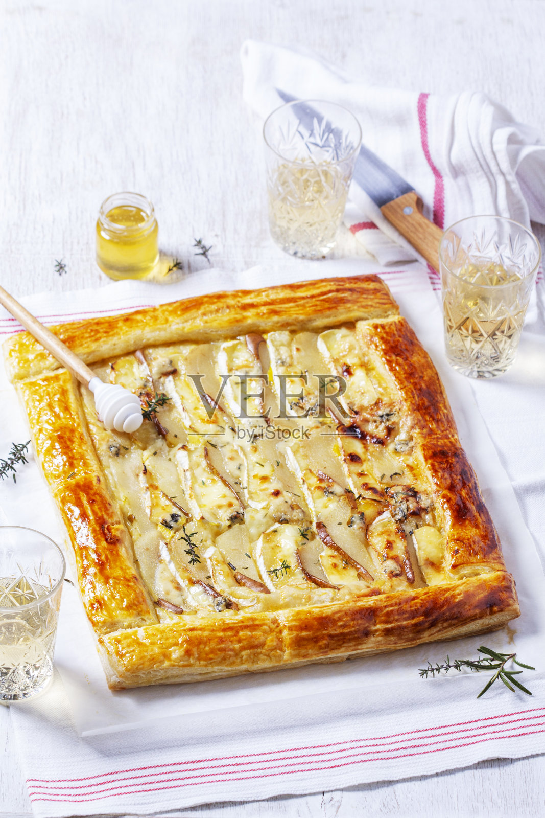 酥皮派,配芝士、梨、坚果和蜂蜜,配香槟。照片摄影图片