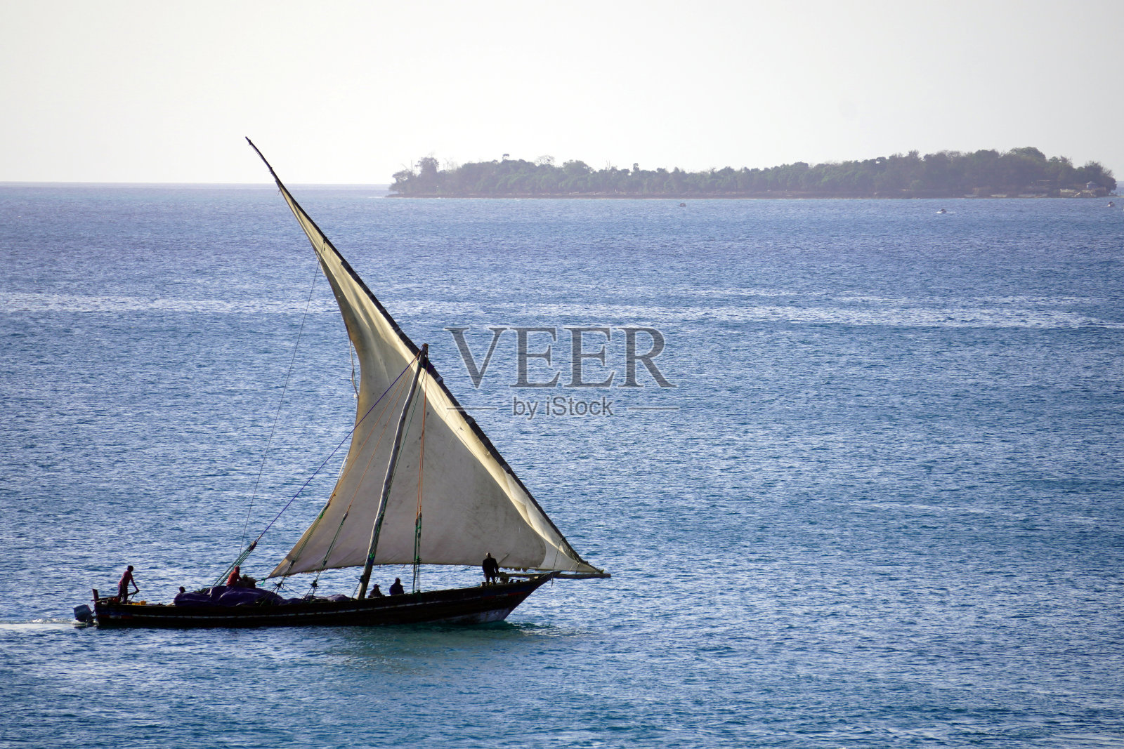 在平静的海面上划单桅帆船照片摄影图片
