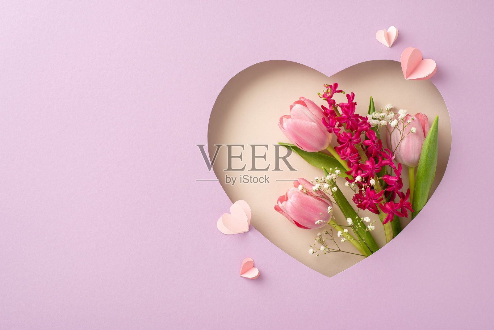 母亲节的优雅:新鲜的郁金香、风信子、吉思兰的俯视图,在柔和的紫色背景上,心形的镂空框架下排列着心形的心。完美的问候短信,个性化的空间照片摄影图片
