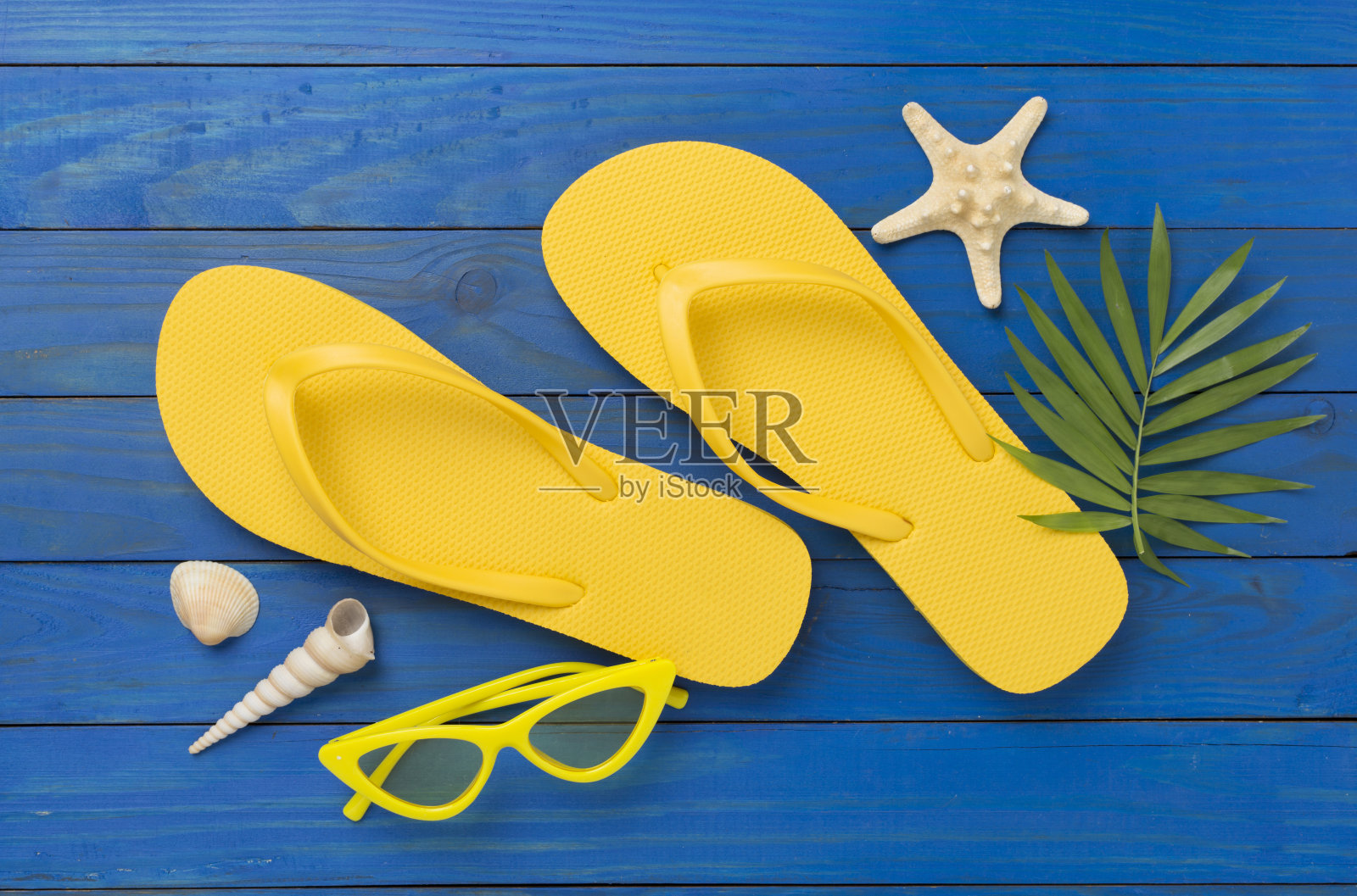 亮黄色人字拖,木质背景,俯视图。夏天的概念照片摄影图片