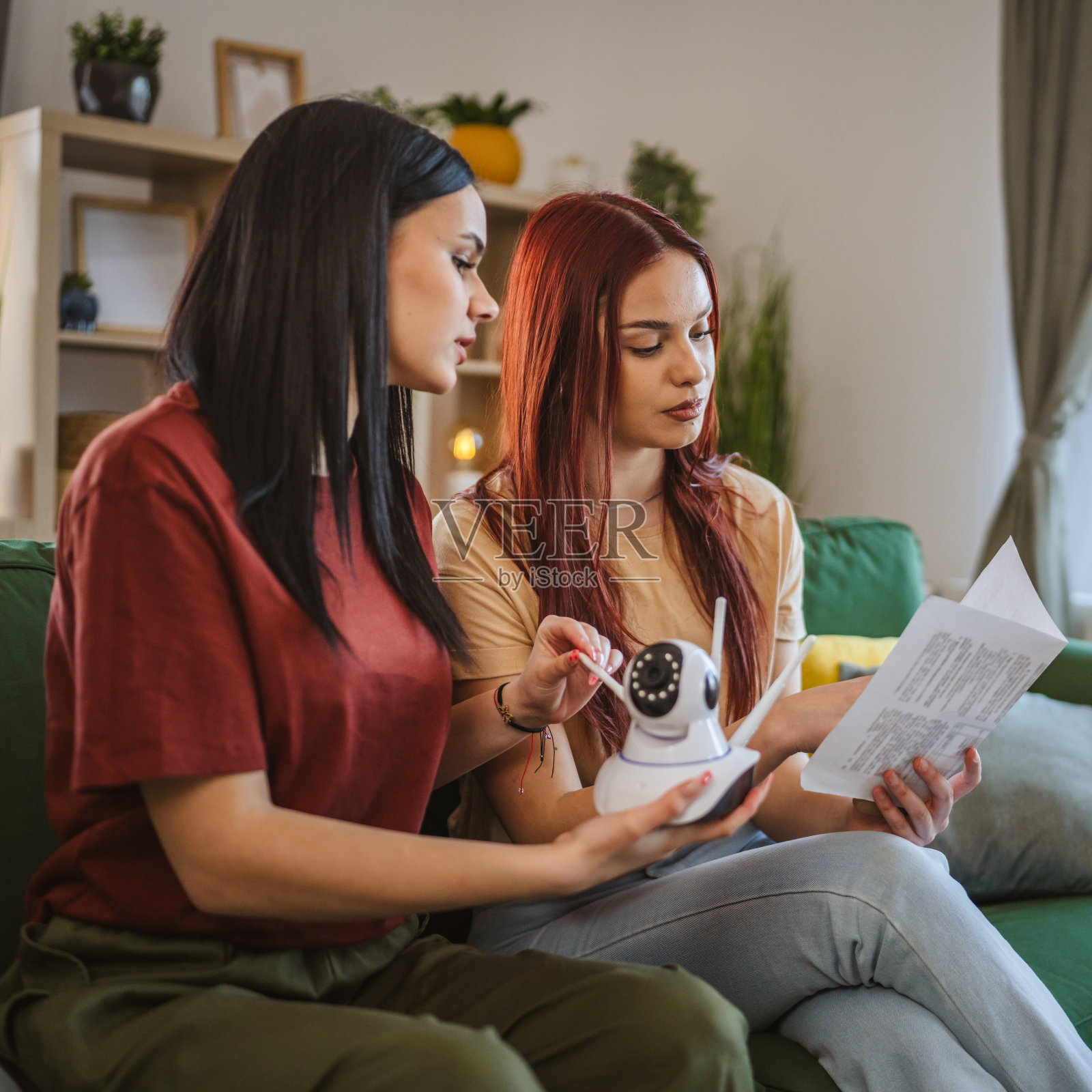 两女姐妹连接安装闭路电视安全监控摄像头照片摄影图片