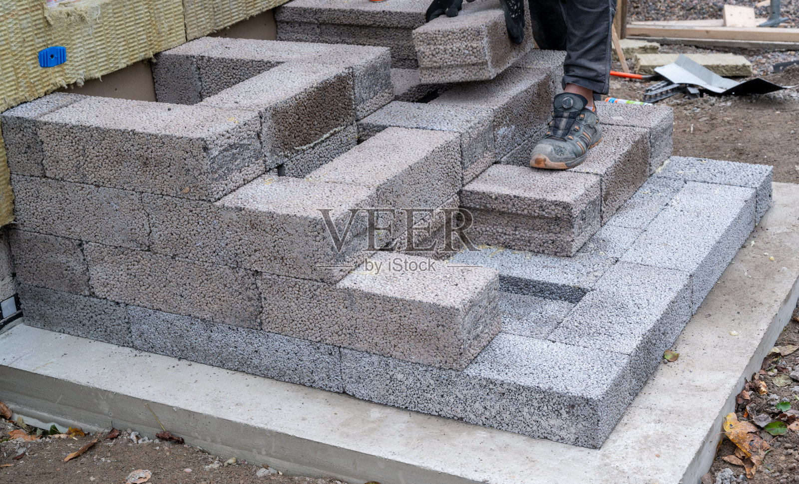 工人用轻质煤渣砖建造通往入口的台阶照片摄影图片