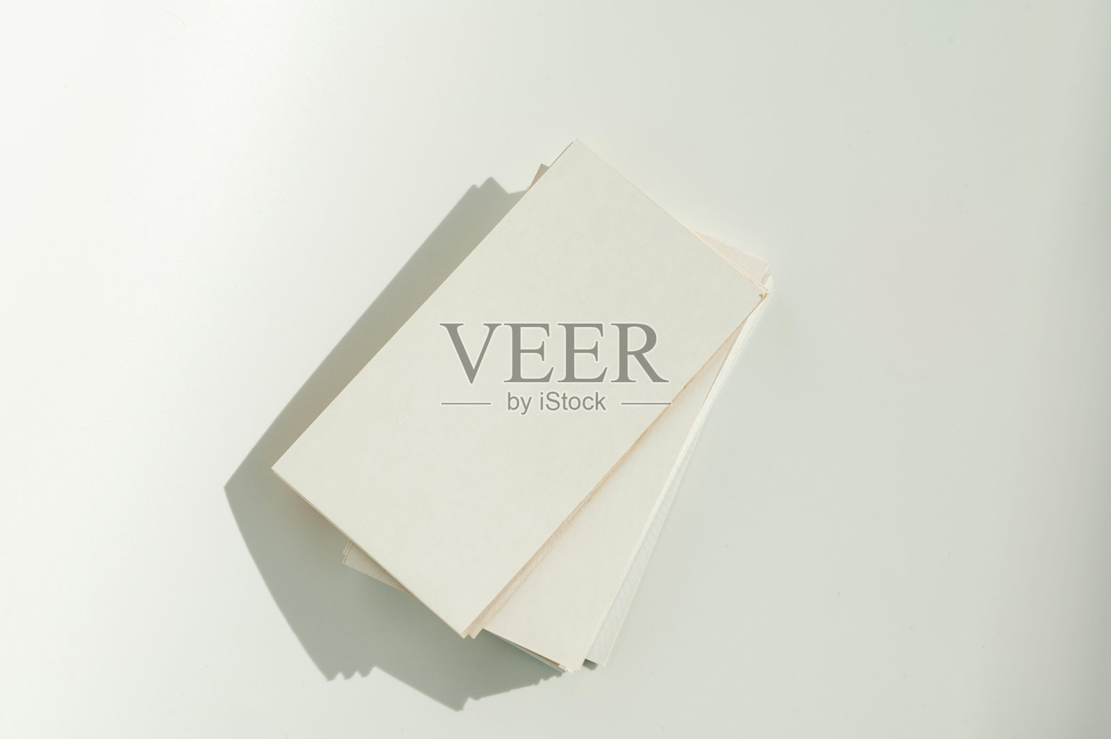 牛皮纸背景上的白色空白名片,带有柔和的阴影。照片摄影图片