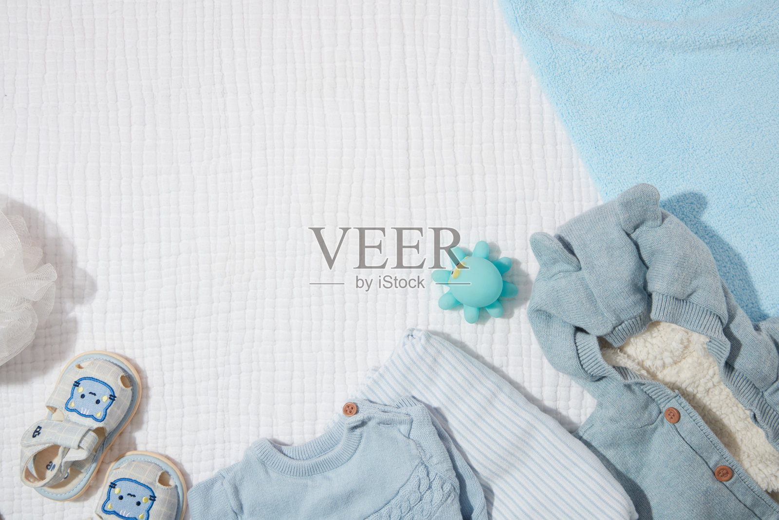 白色和蓝色亚麻布毛巾背景与一套衣服的婴儿在蓝色的色调从顶视图。展示或展示婴儿护理产品的空白空间照片摄影图片