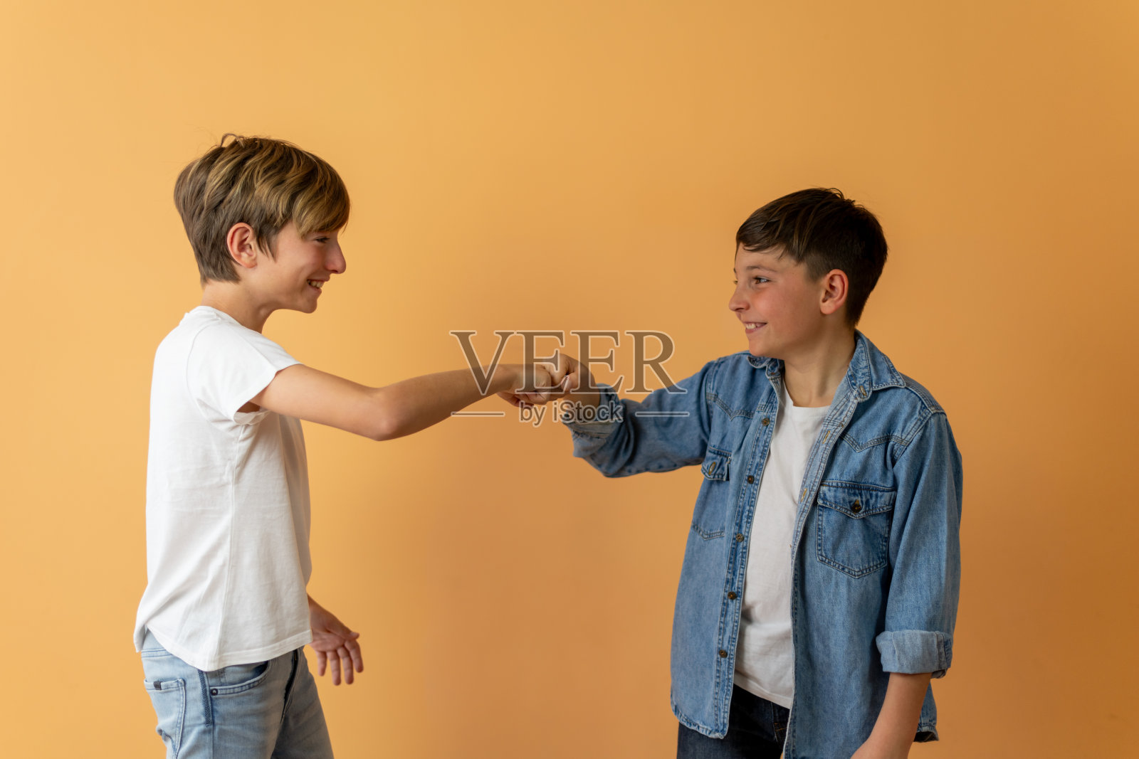 两个孩子互相碰拳打招呼照片摄影图片