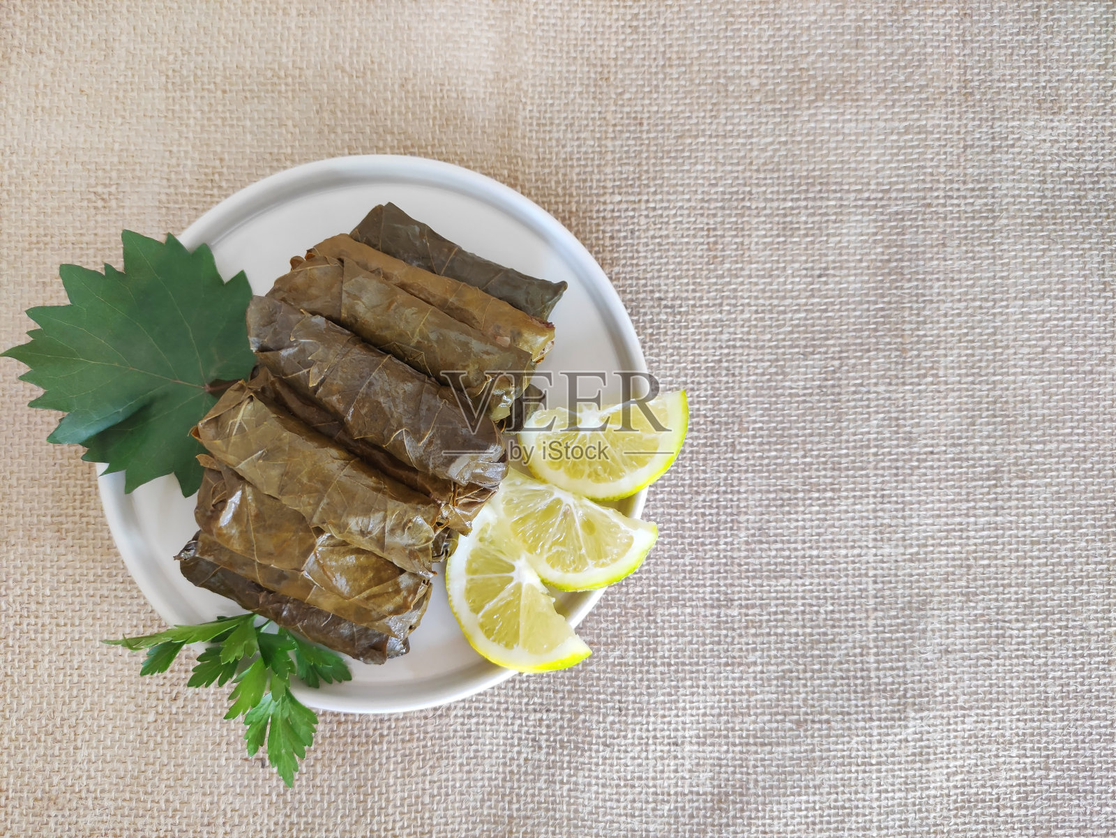 传统的东方土耳其dolma,由葡萄叶和米饭塞在装饰盘上制成照片摄影图片