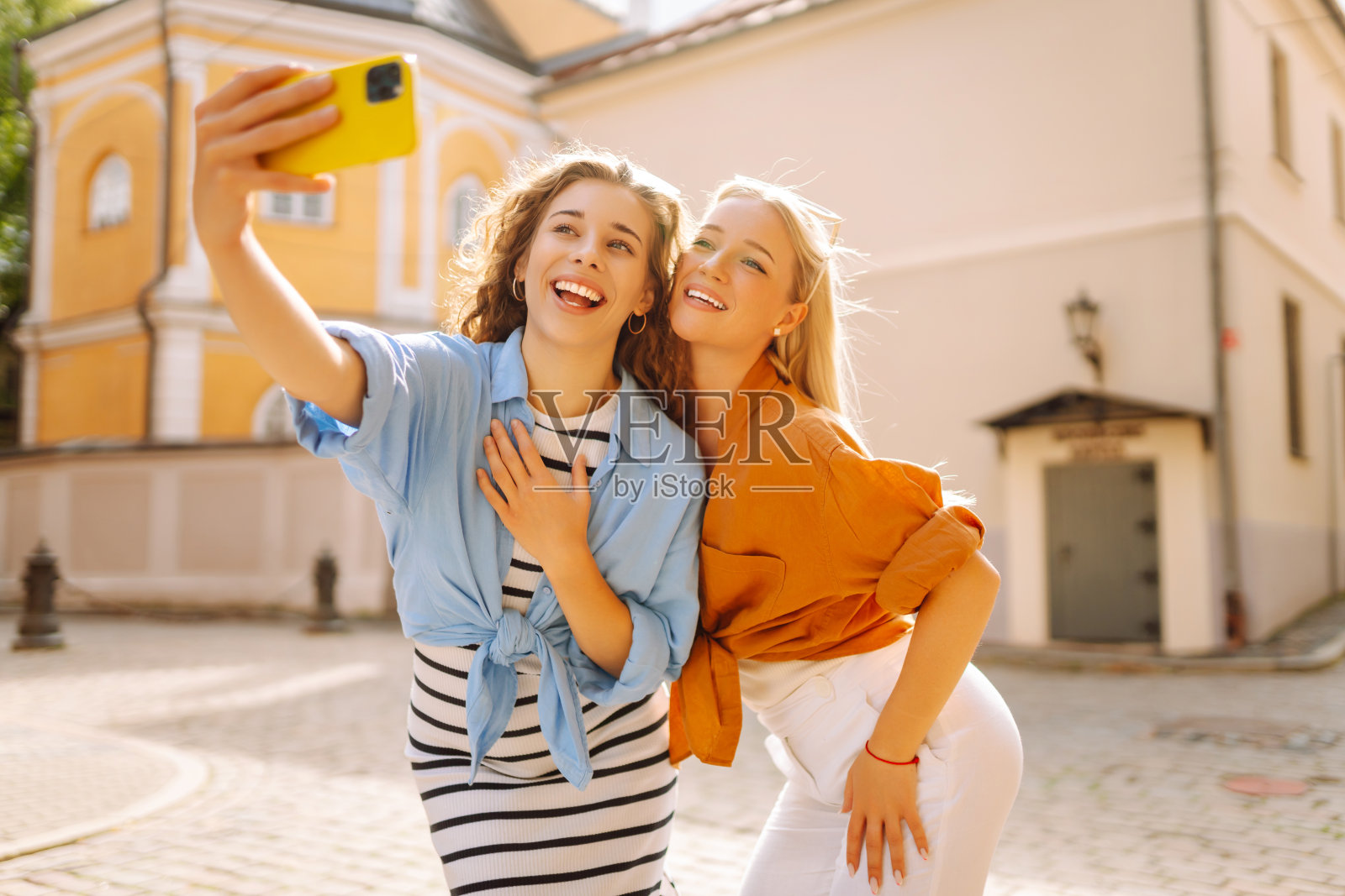 一名女游客走在街上,用智能手机自拍。照片摄影图片