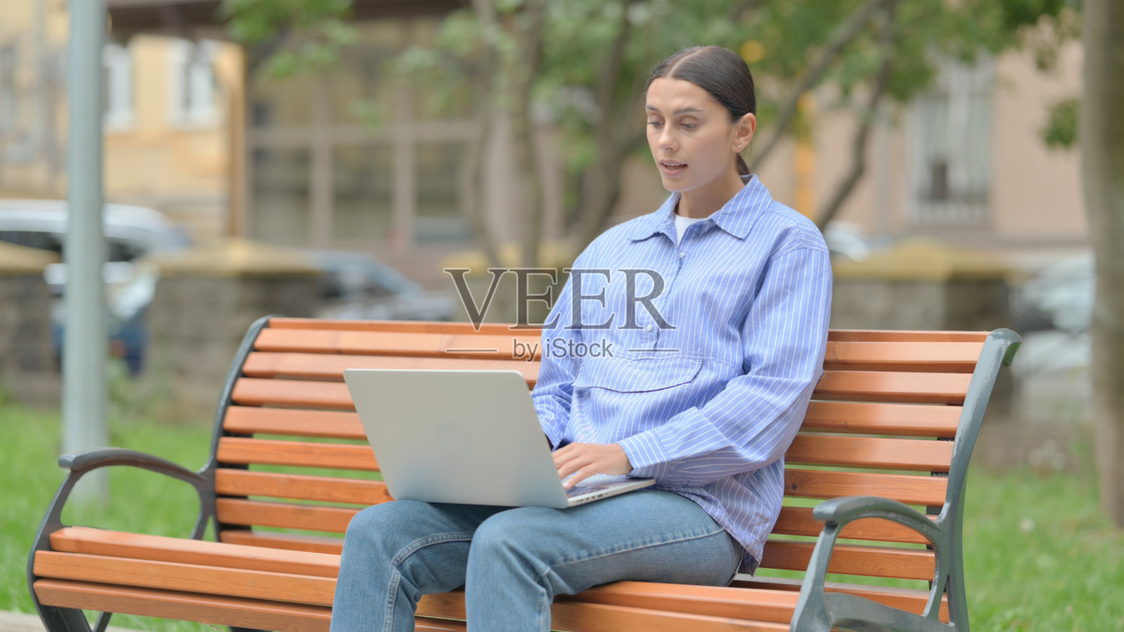 西班牙裔妇女在户外笔记本电脑上在线视频聊天照片摄影图片