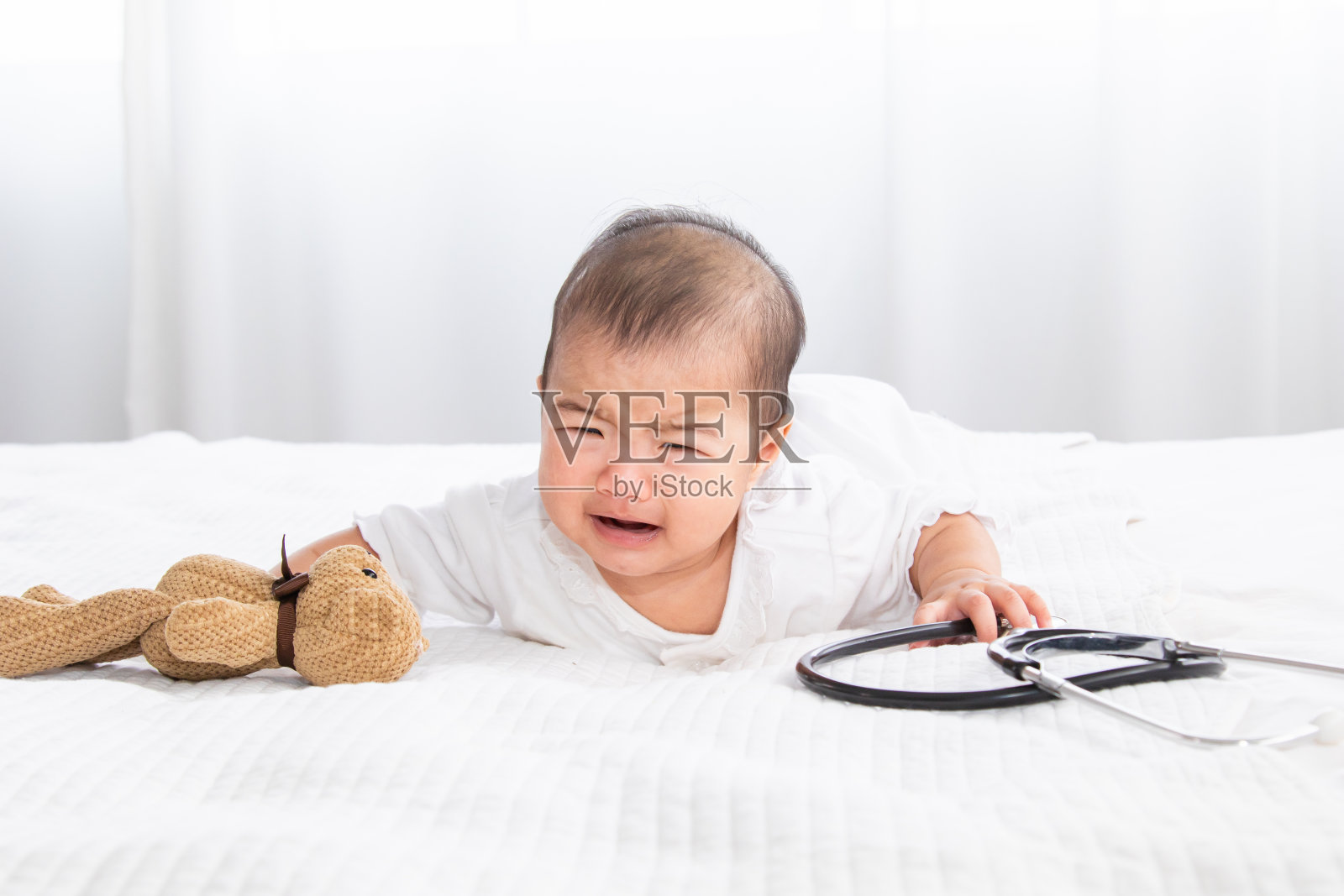 幼儿新生儿穿着紧身衣的特写镜头,休闲柔软的触感舒适的独自躺在床上,看着相机在家里,保健和儿科。婴儿保健品概念。照片摄影图片