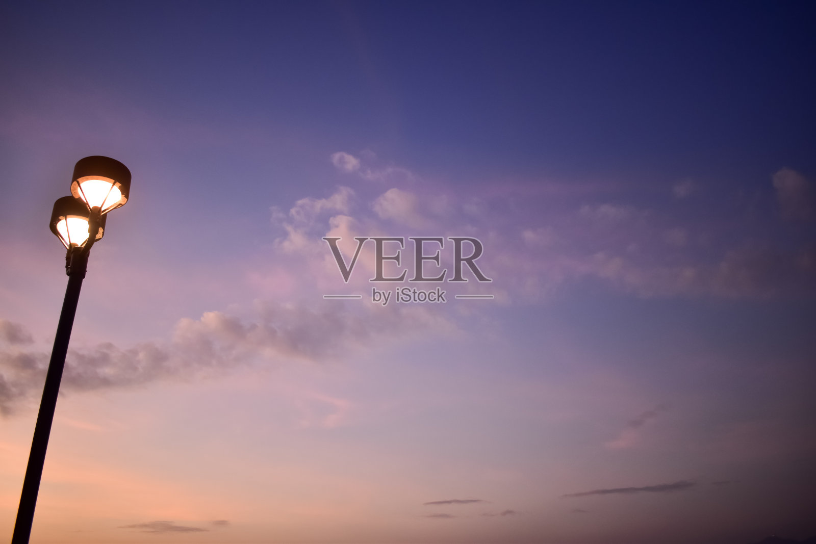 日落时街灯的特写,街道上的城市灯光与天空背景。照片摄影图片