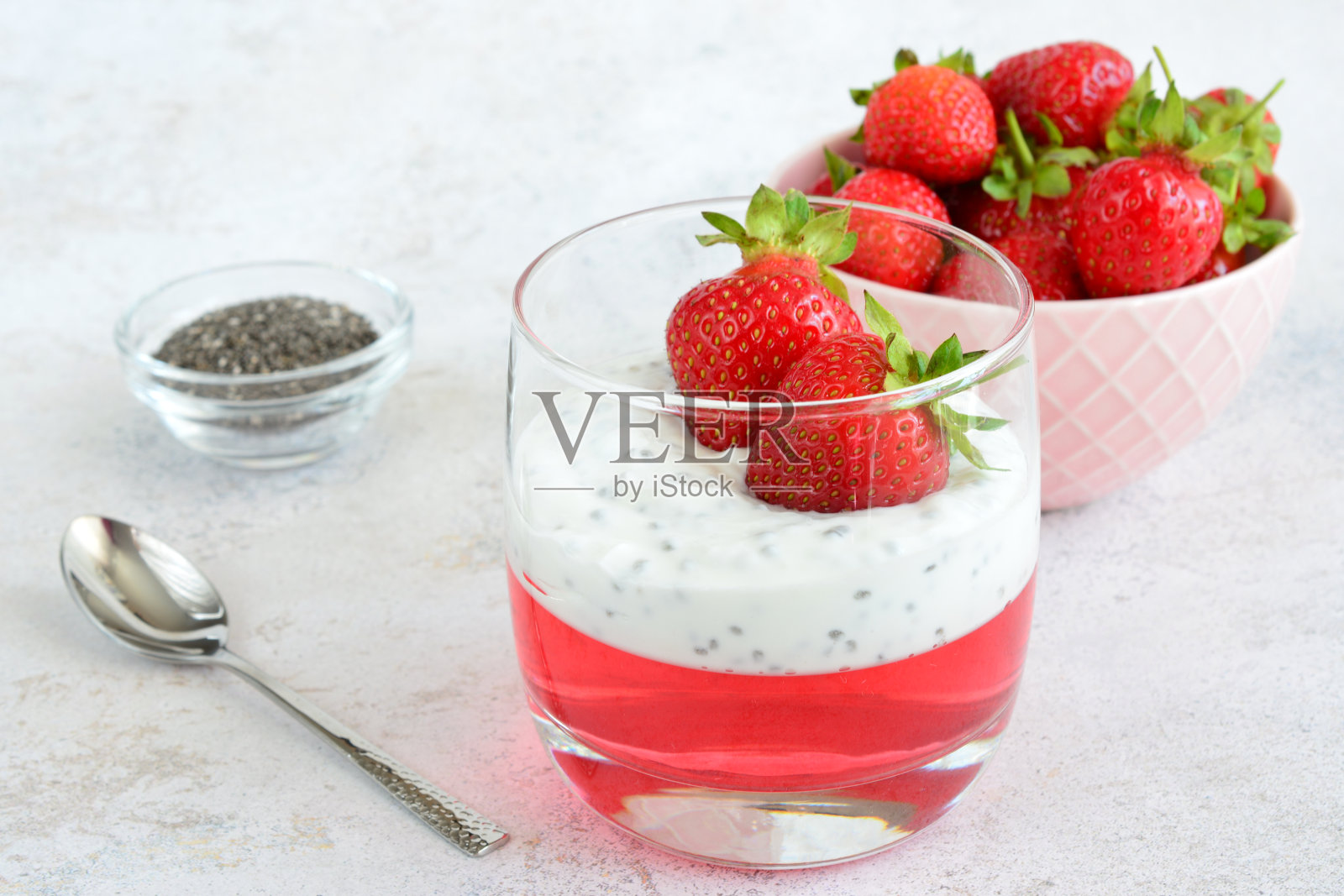 一杯草莓酸奶,旁边放个勺子照片摄影图片