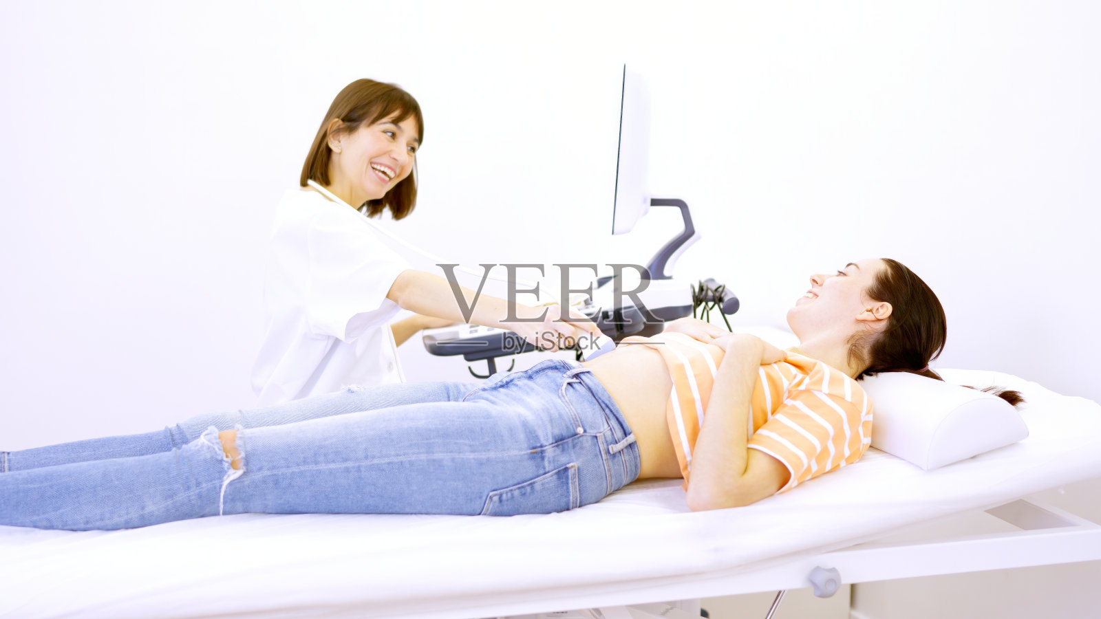 医生通过超声波告诉病人她怀孕了照片摄影图片