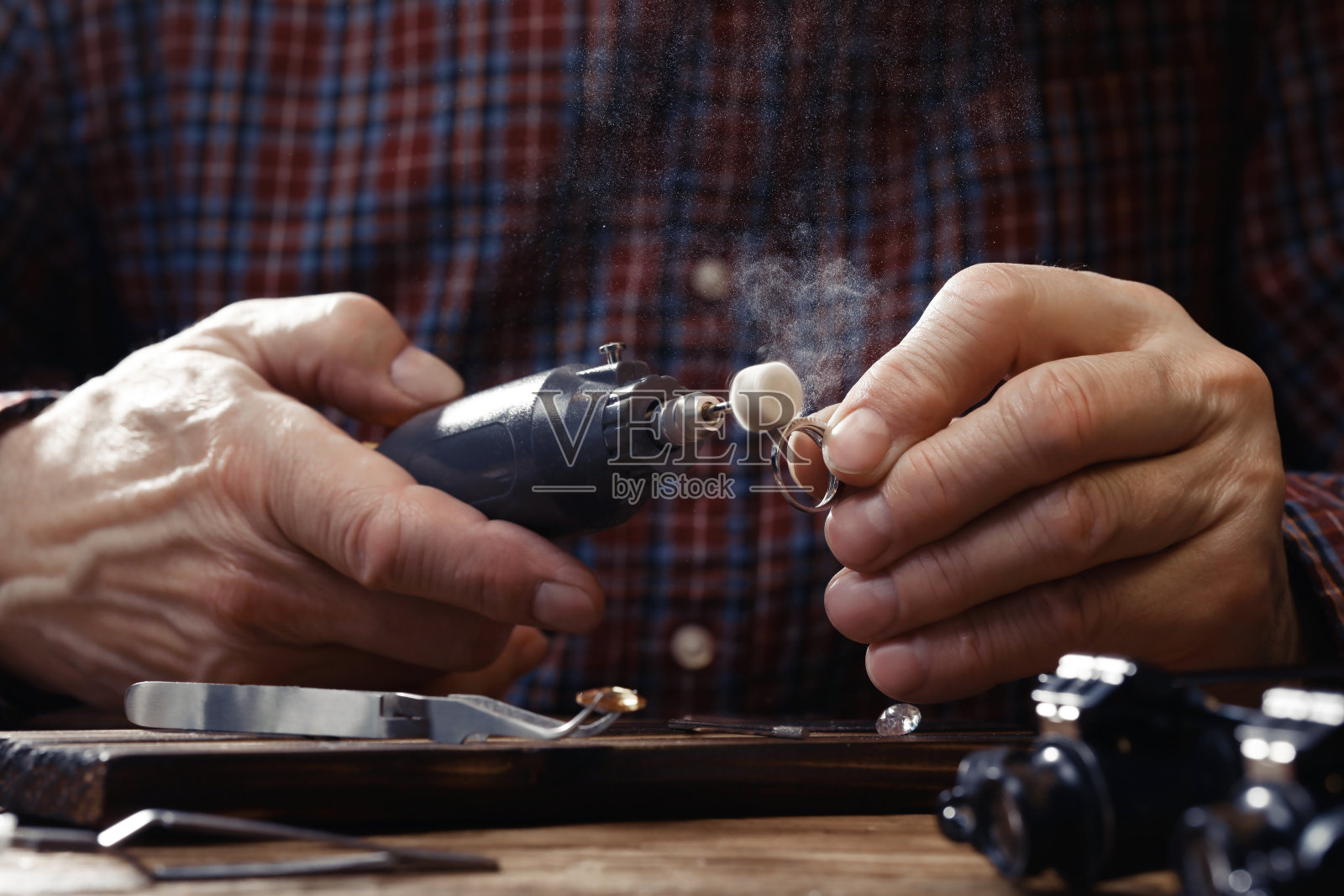 专业珠宝商工作与戒指在木桌,特写照片摄影图片