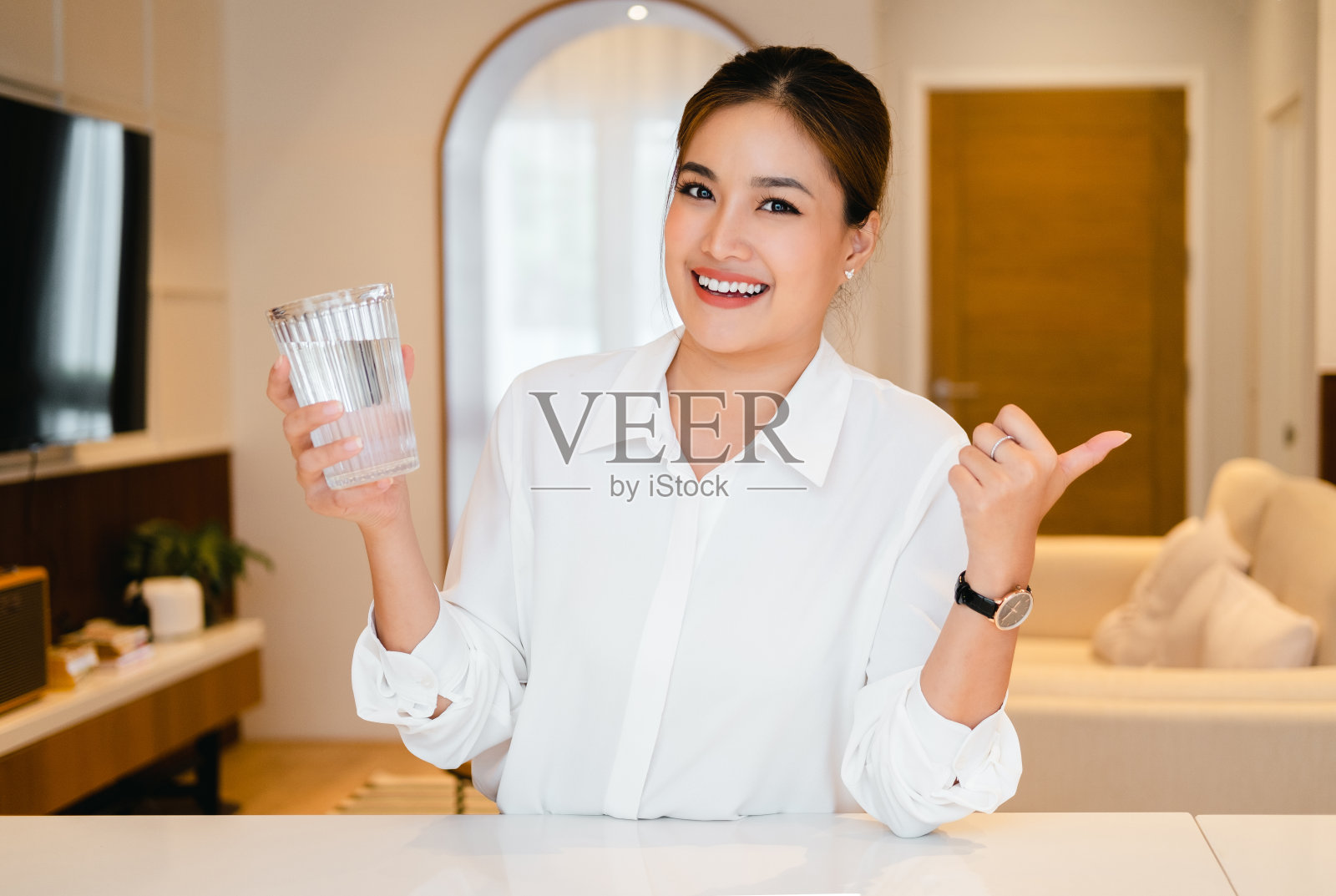 健康的液体。亚洲女孩从玻璃杯里喝干净的水,自由空间照片摄影图片