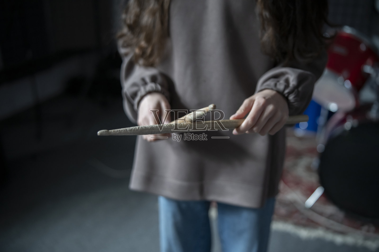 鼓手站在排练室里,手握着鸡腿照片摄影图片